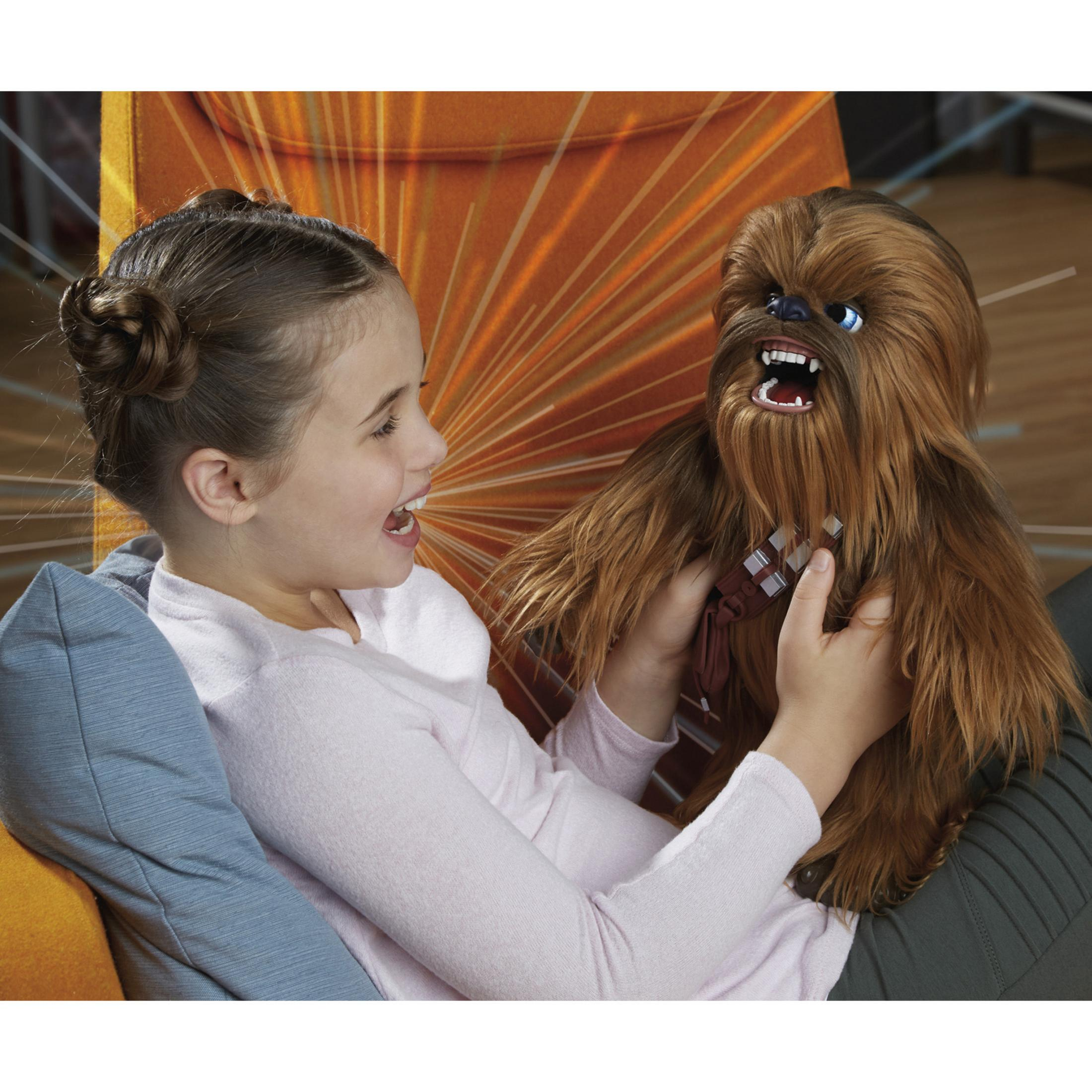 Una ragazza con i capelli raccolti in chignon gioca con una bambola di Chewbacca.