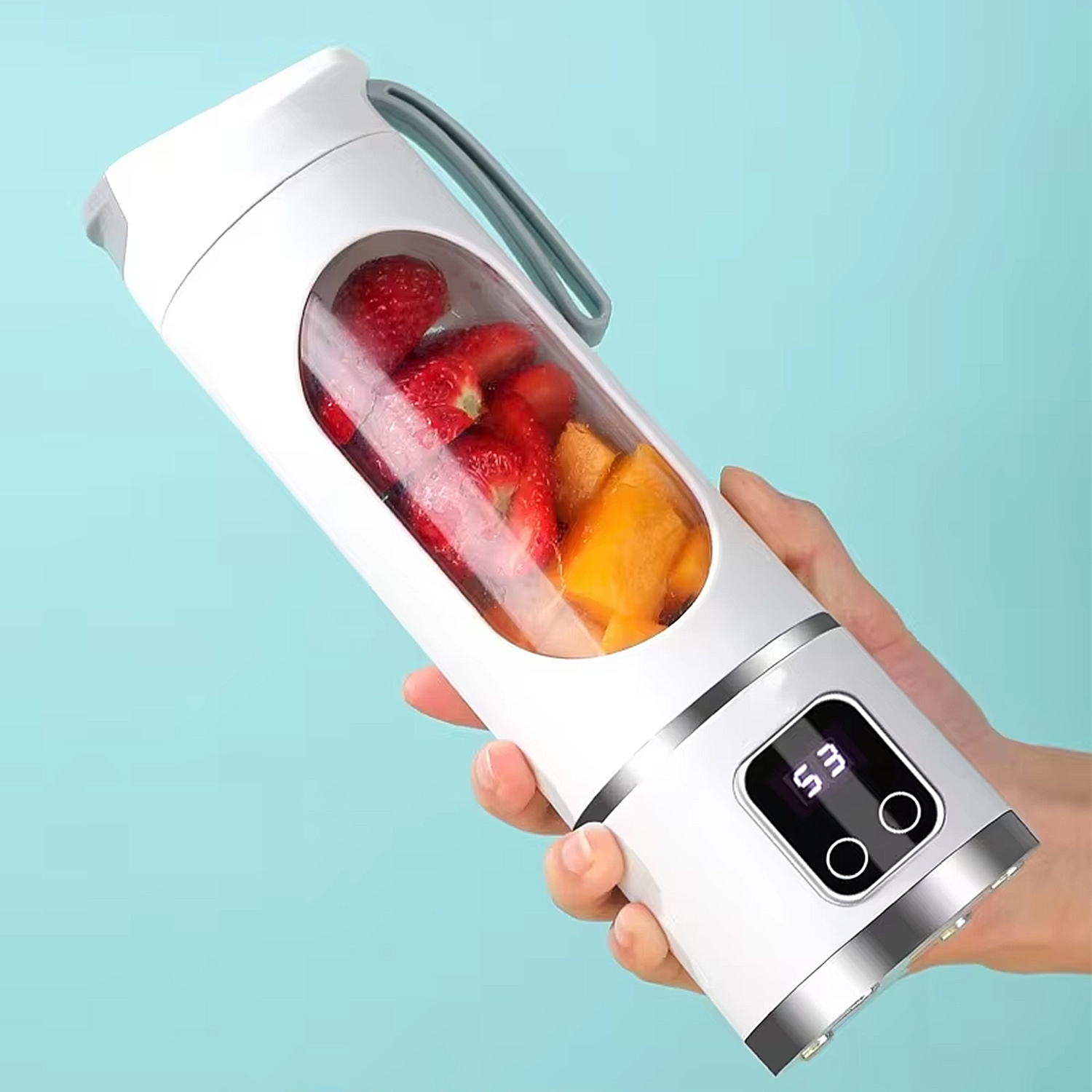 Frullatore portatile bianco con fragole e mango, tenuto in mano.
