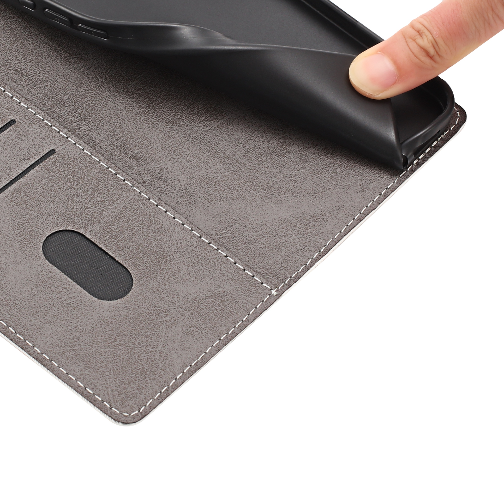 Ein Finger biegt eine schwarze Handyhülle aus Leder. Weiße Nähte.