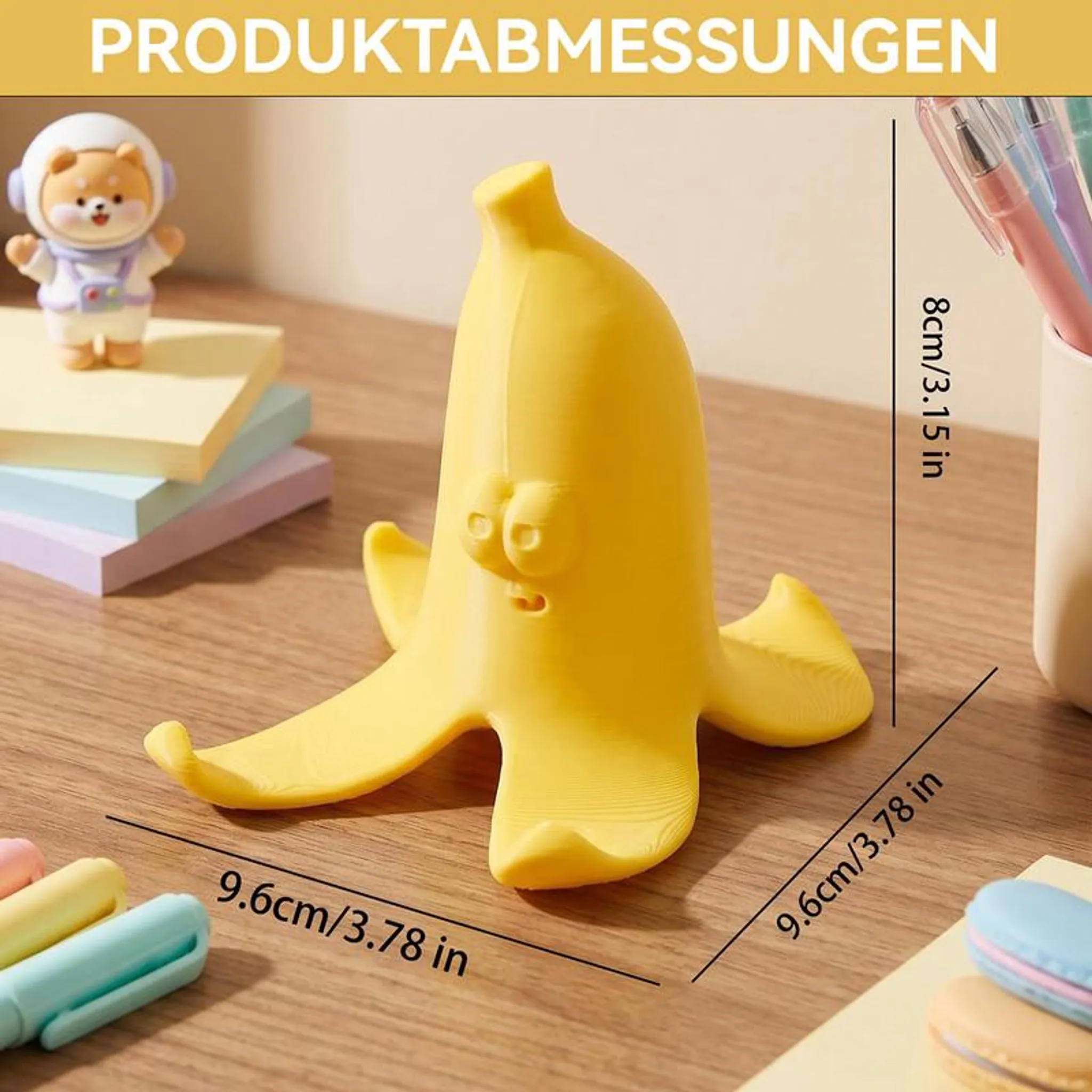 Ein gelber Bananenhalter mit Gesicht, neben einem Astronauten-Bären und Stiften.