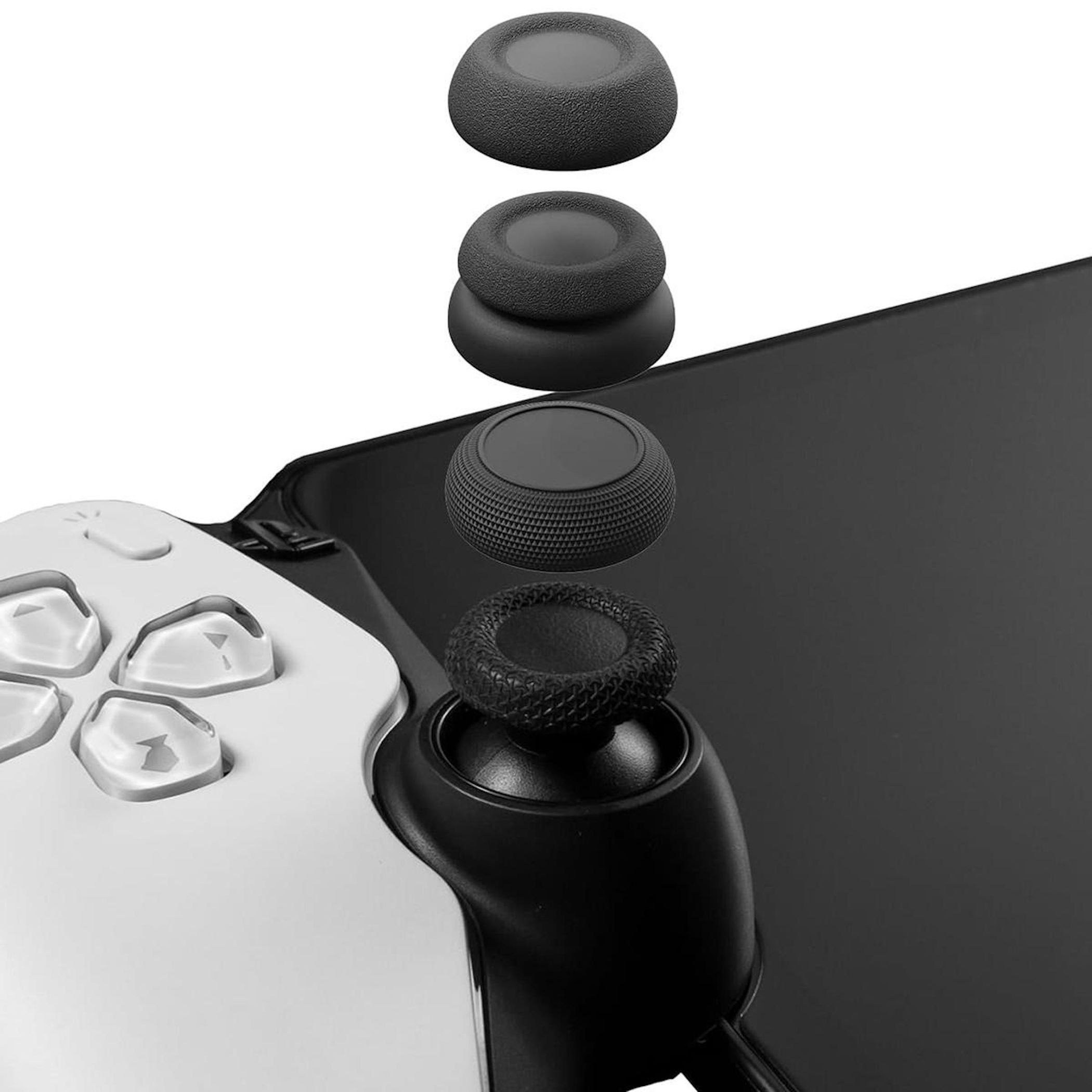 Schwarze Joystick-Aufsätze liegen auf einem Controller und einer schwarzen Fläche.