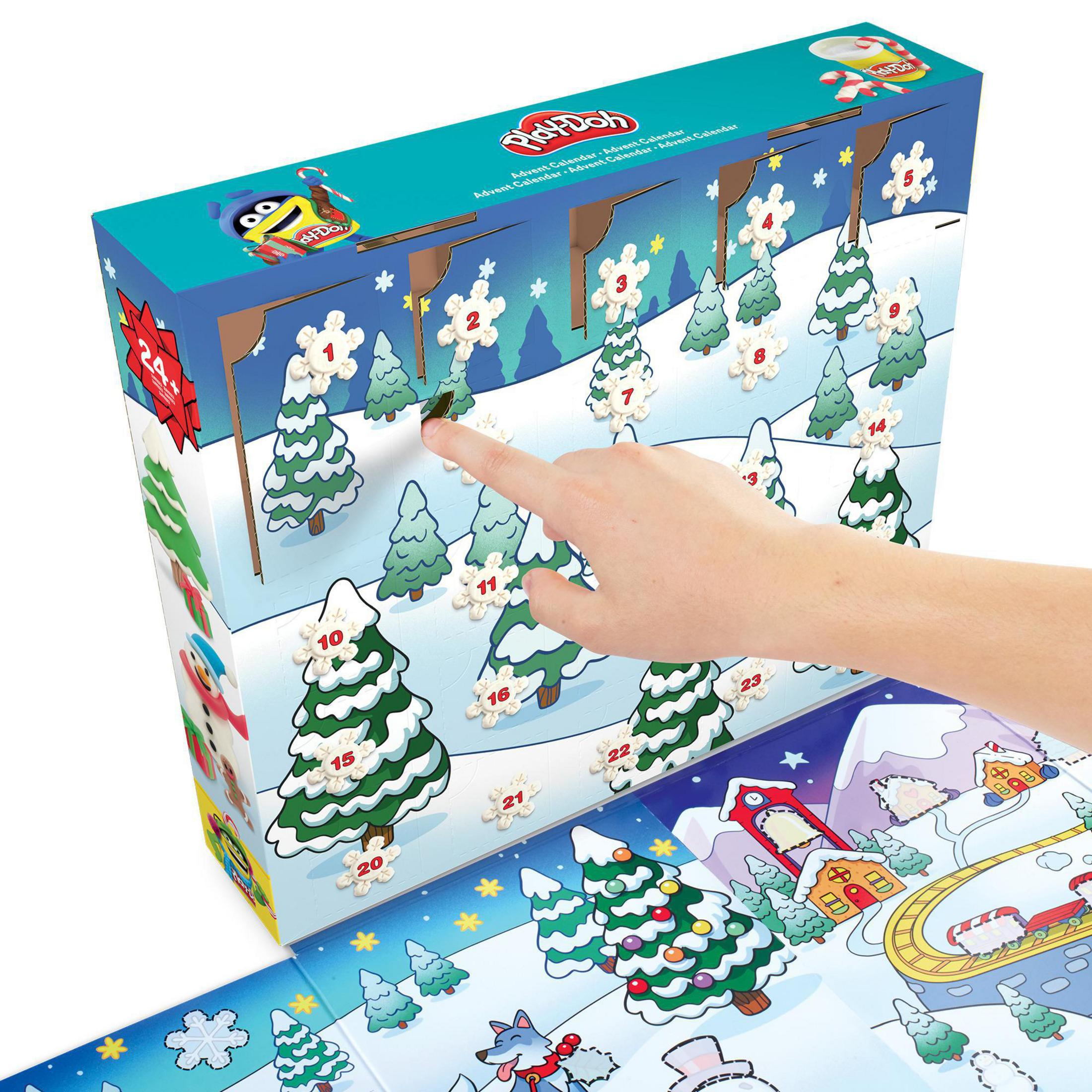 Eine Hand öffnet einen Play-Doh-Adventskalender mit verschneiten Bäumen und nummerierten Schneeflocken.