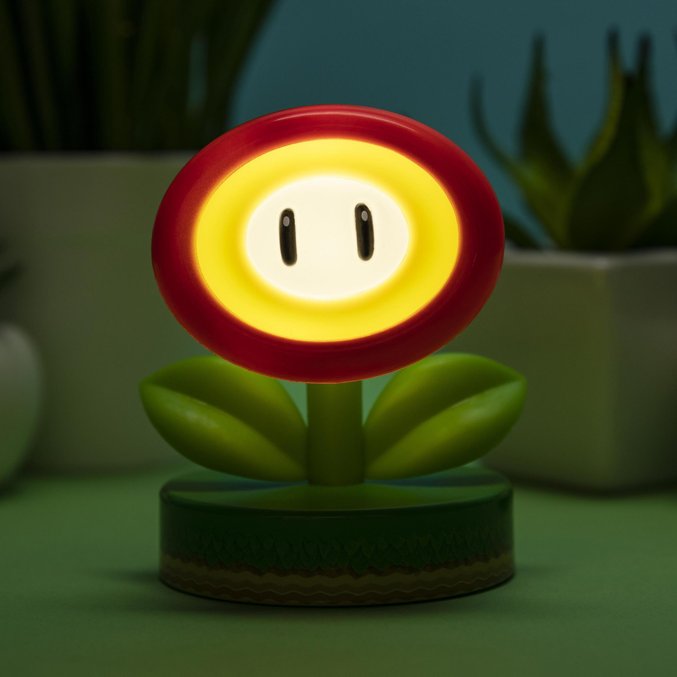 Eine leuchtende, rote Blume mit gelbem Zentrum und zwei schwarzen Augen auf einem grünen Sockel.