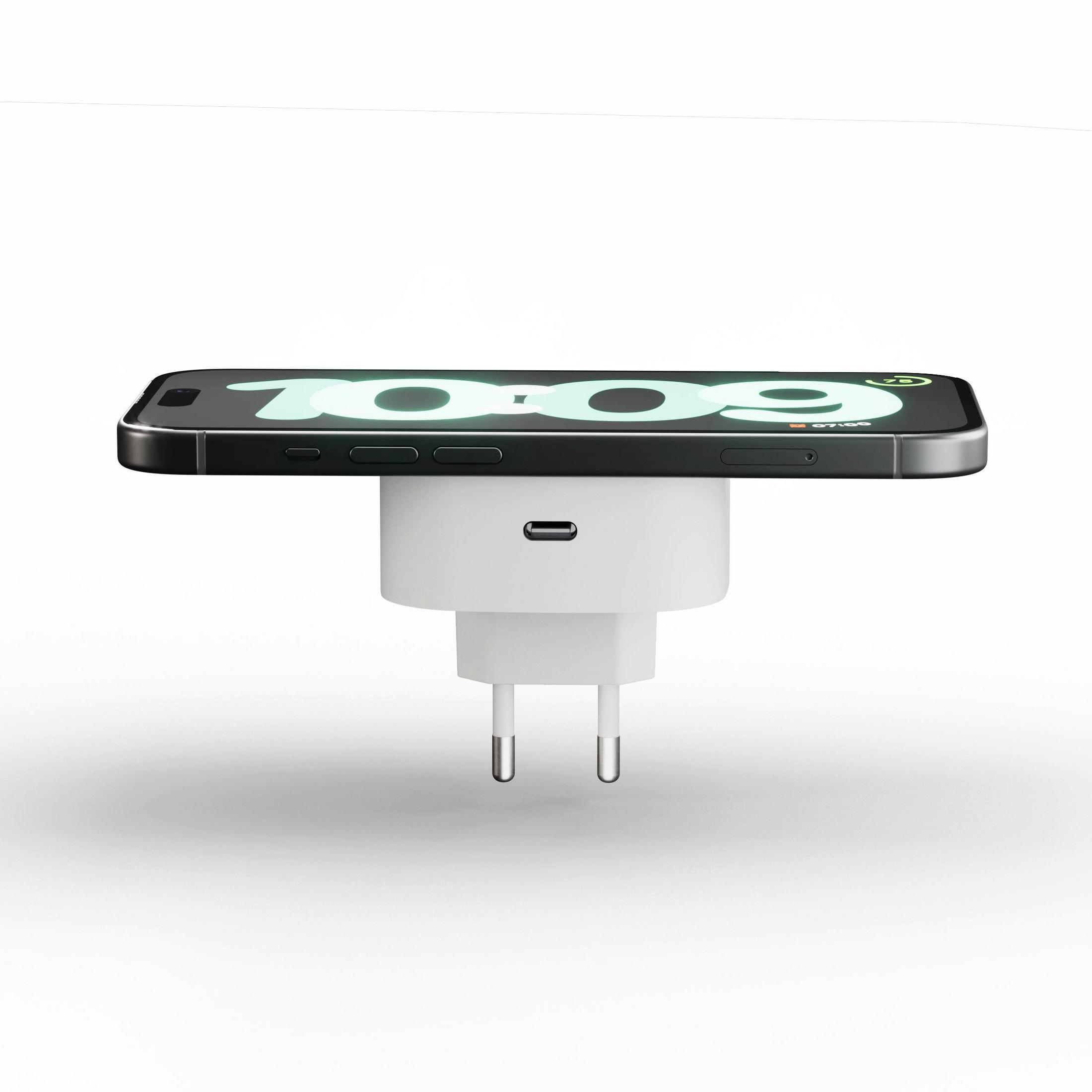 Een witte stekker met USB-C-poort, met daarop een zwarte smartphone die de tijd toont.