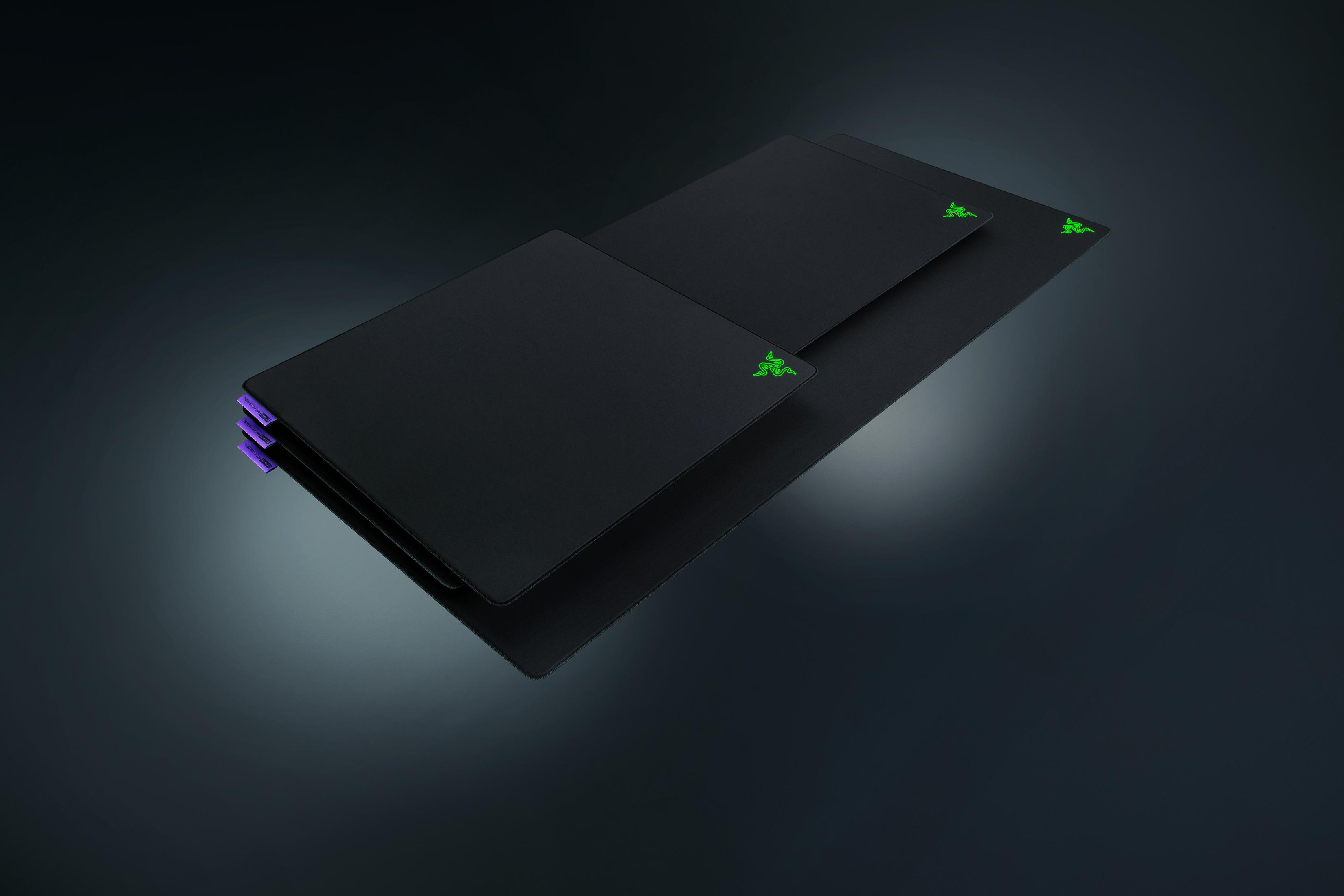 Trois tapis de souris Razer noirs superposés, avec logos verts.