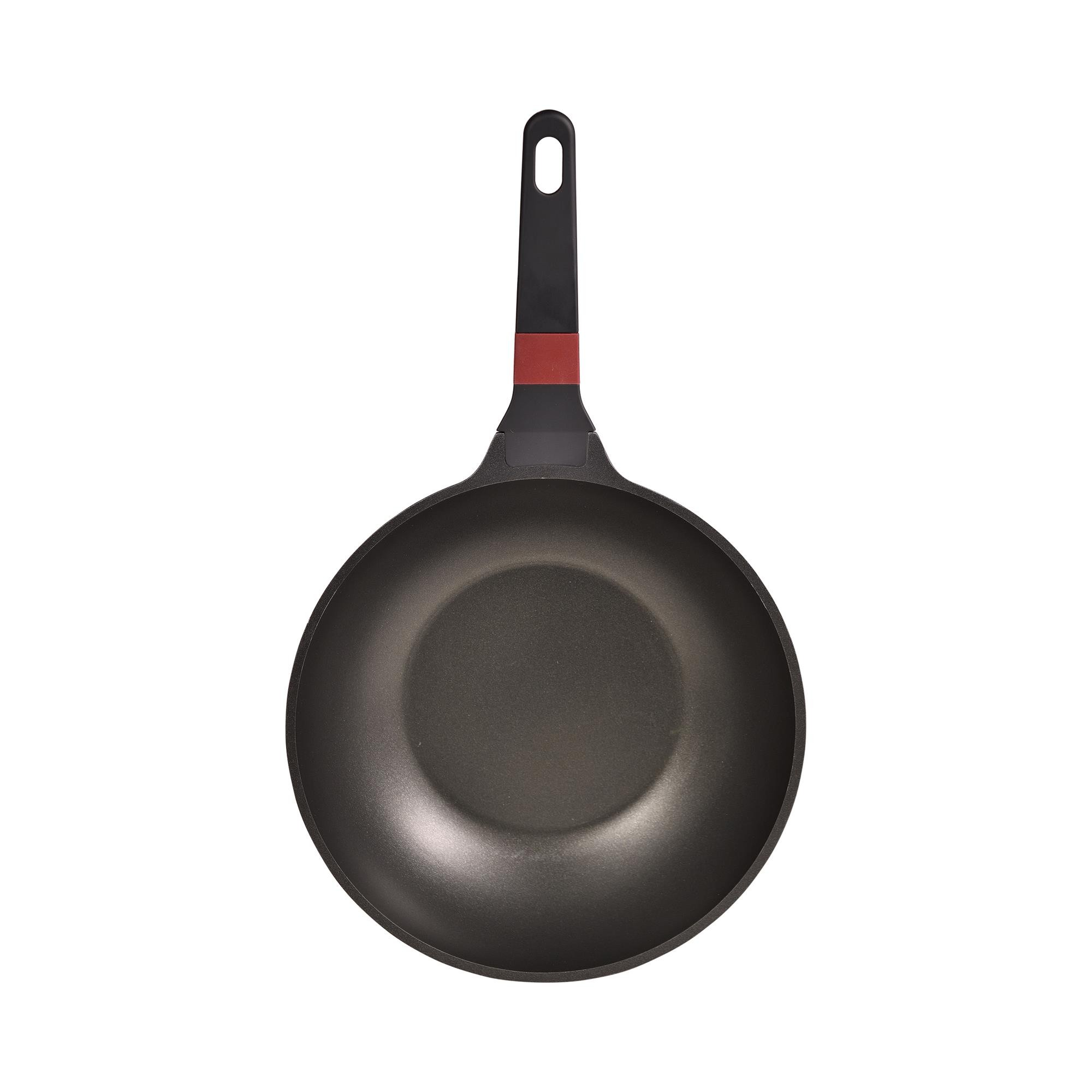 Una sartén wok negra con mango rojo y negro, aislada sobre blanco.