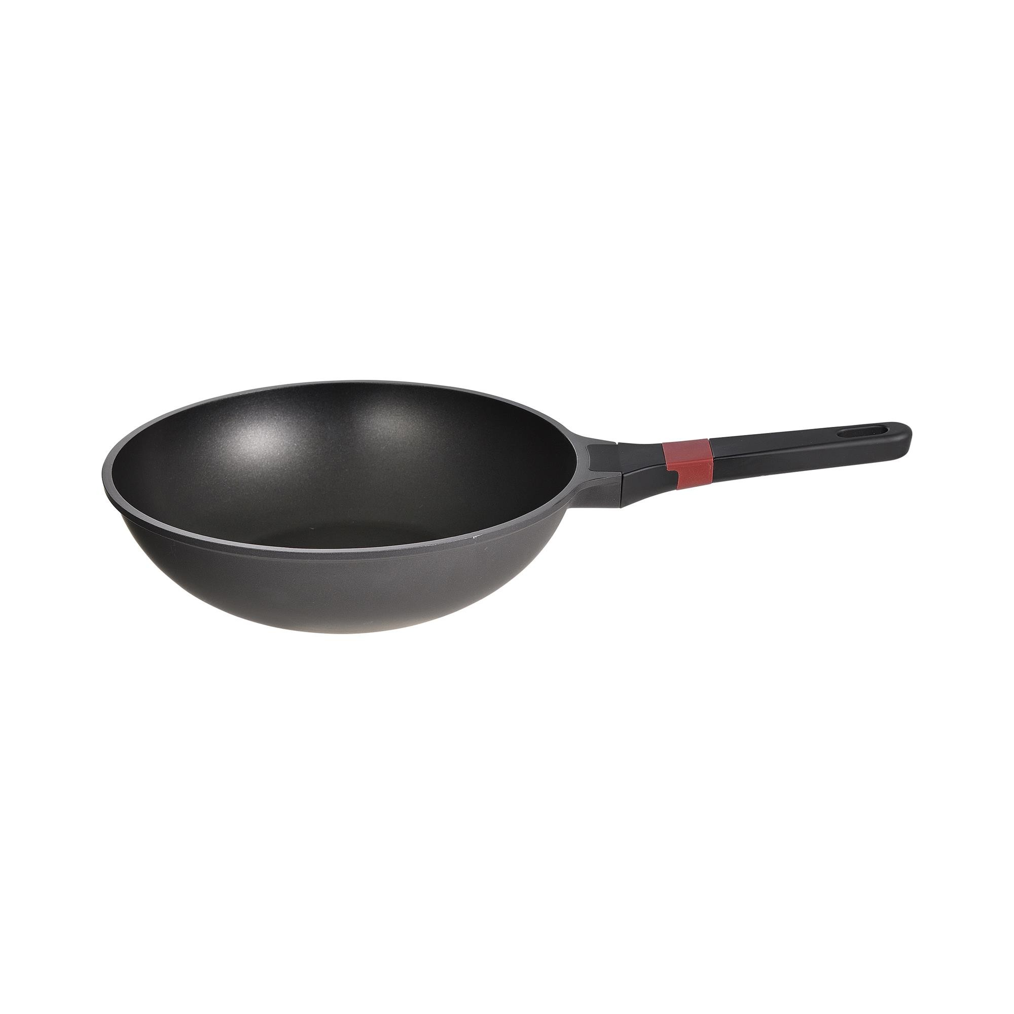Un wok negro con un acento rojo en el mango, aislado sobre blanco.