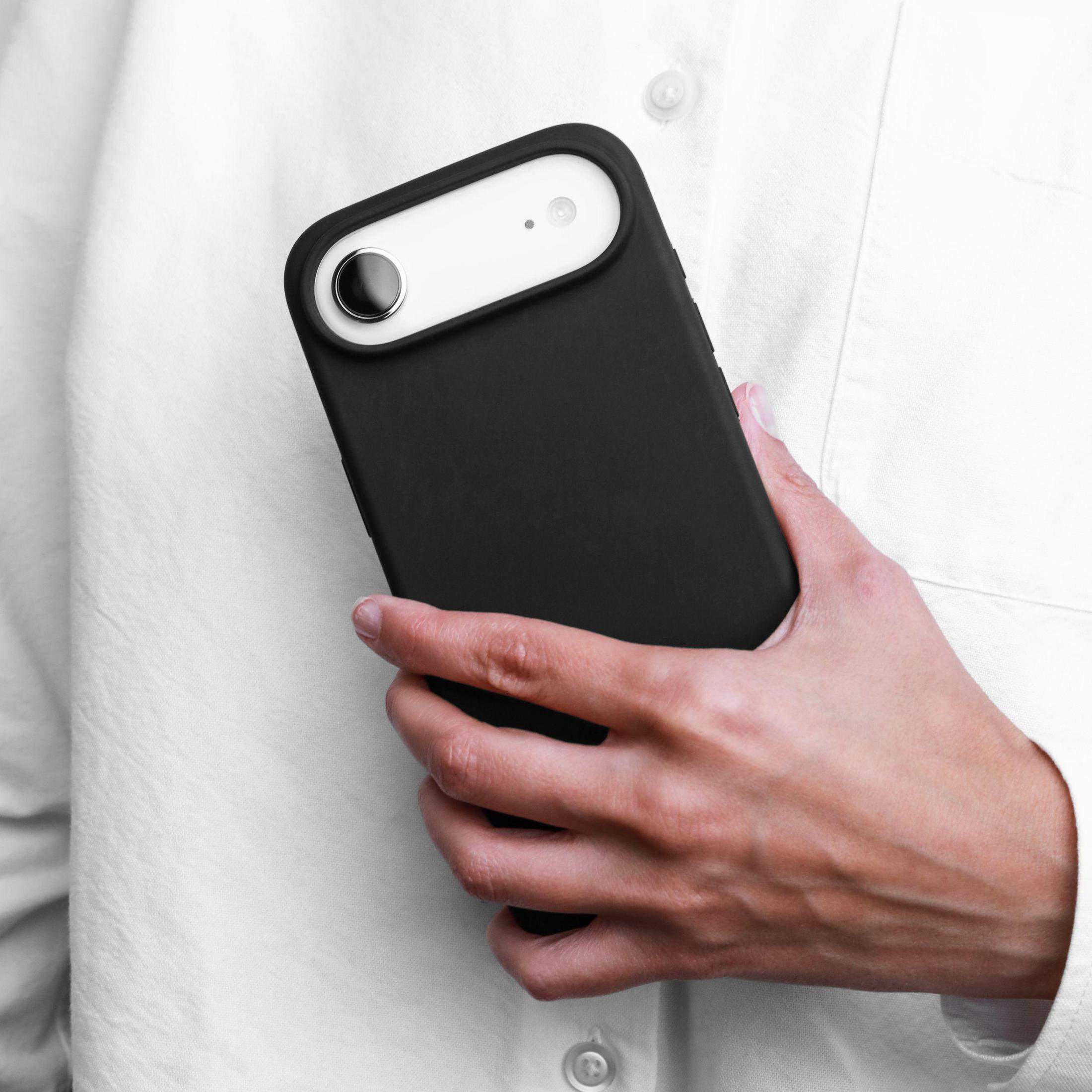 Eine Hand hält ein schwarzes Handy mit einem weißen Streifen auf der Rückseite.