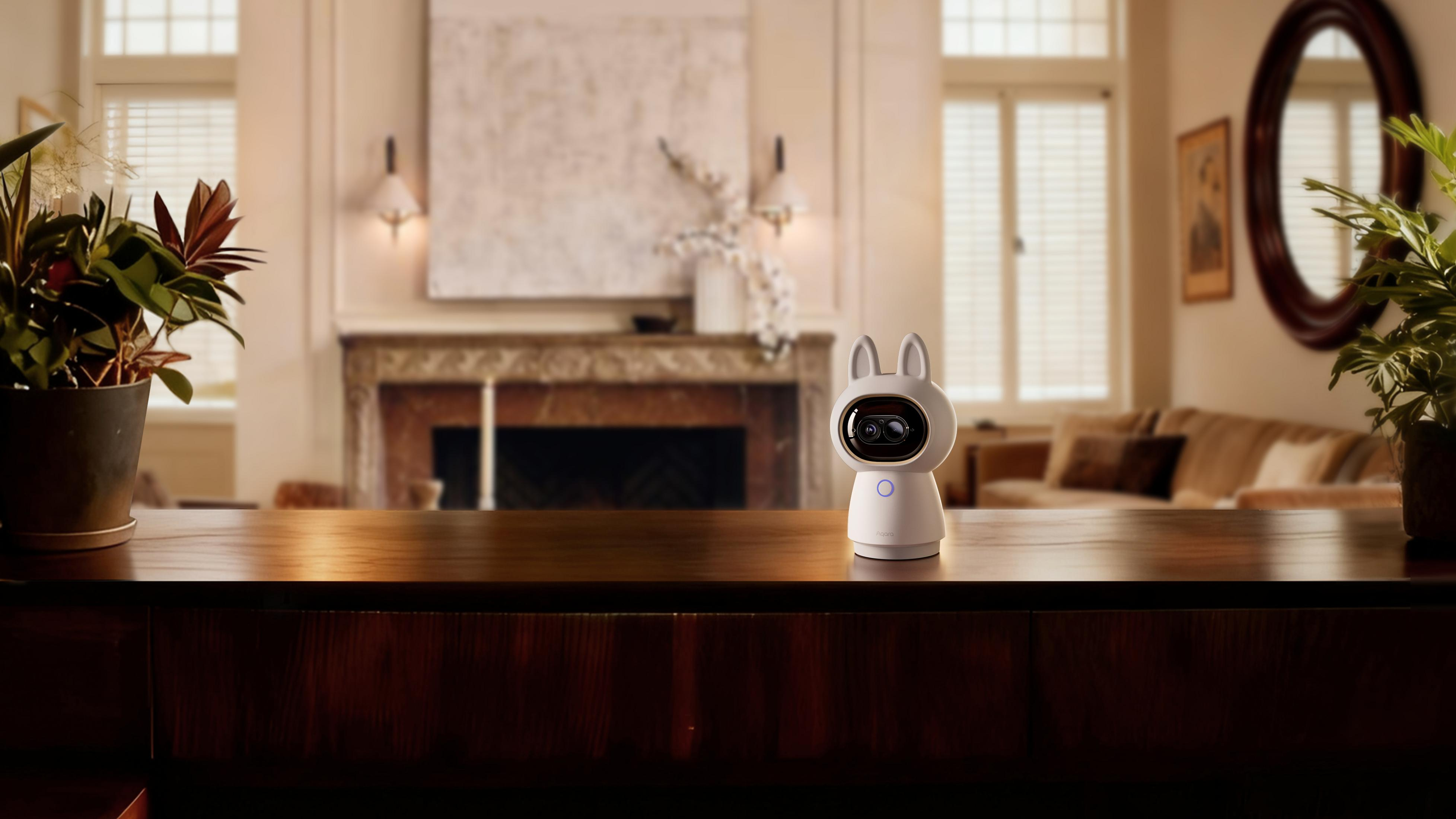 Ein weißer Roboter mit Hasenohren sitzt auf einem Holztisch in einem Wohnzimmer.