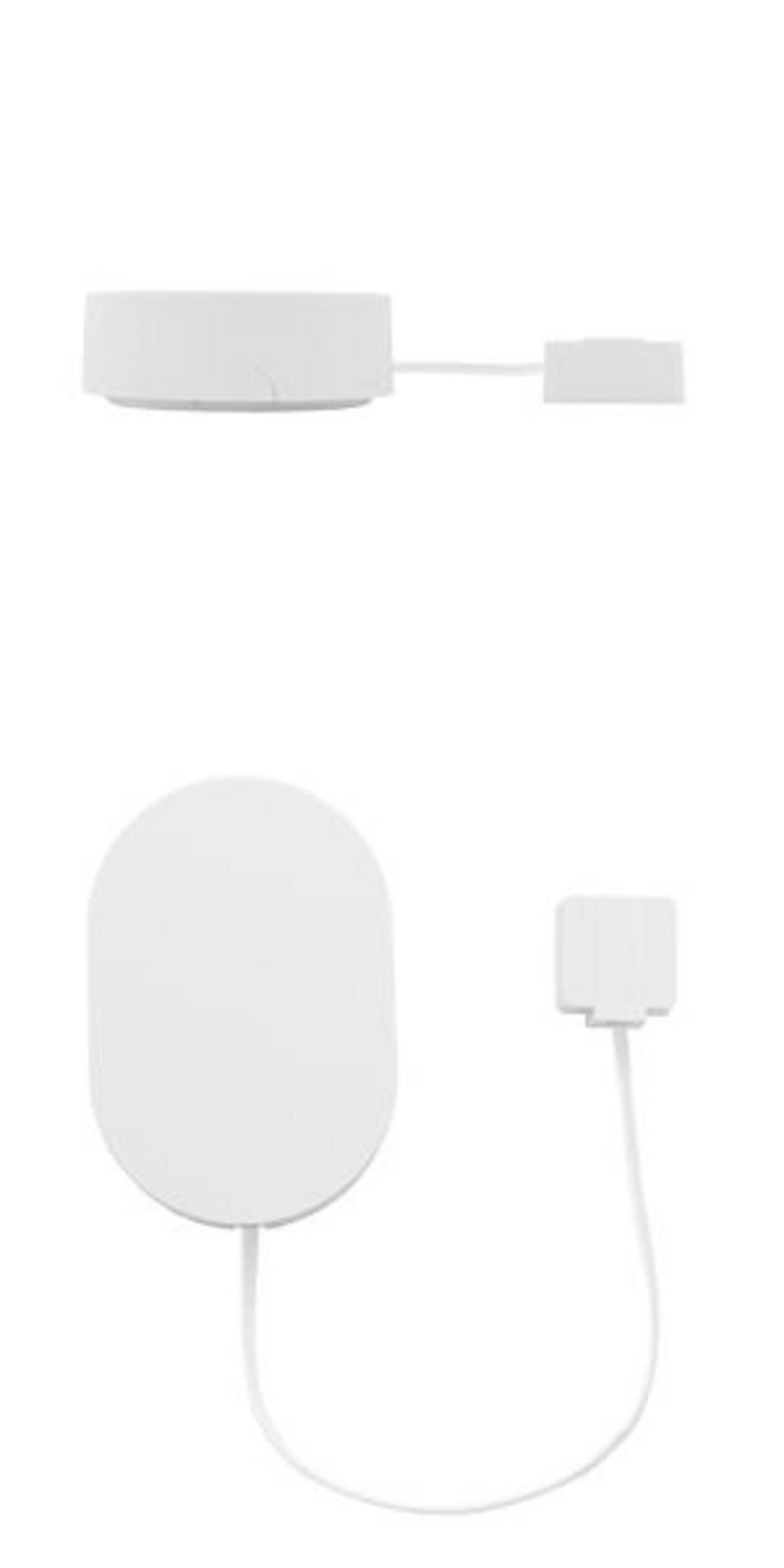 Ein weißes kreisförmiges Ladegerät mit einem abnehmbaren Stecker.