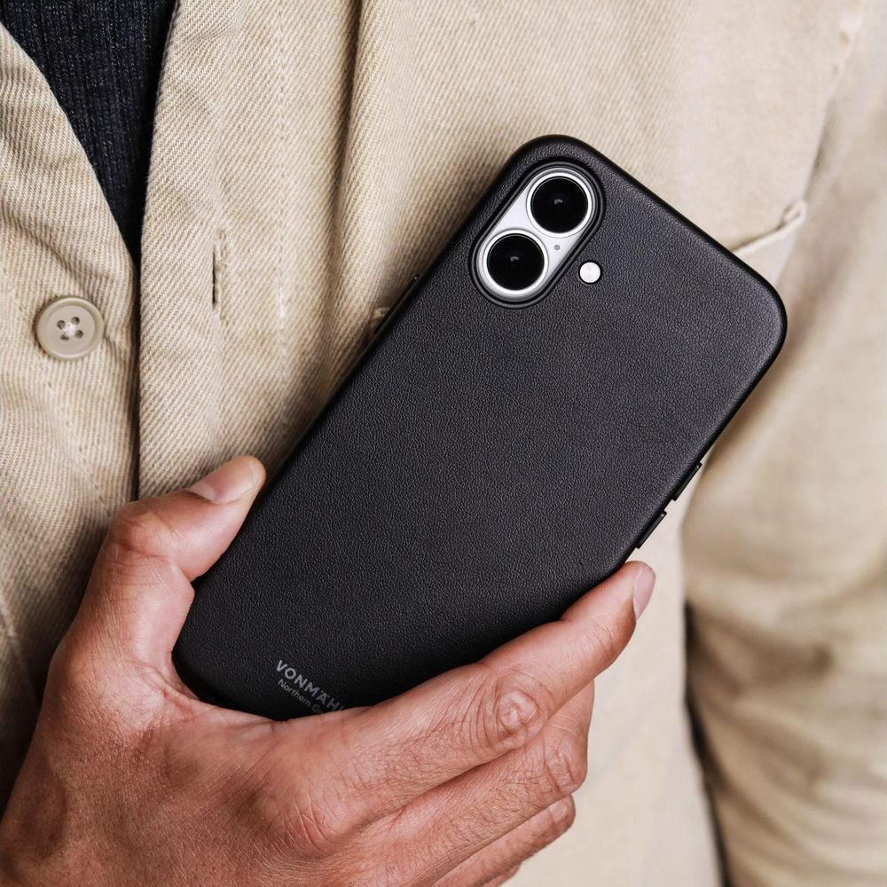 Eine Person hält ein schwarzes Handy mit zwei Kameras in der Hand.