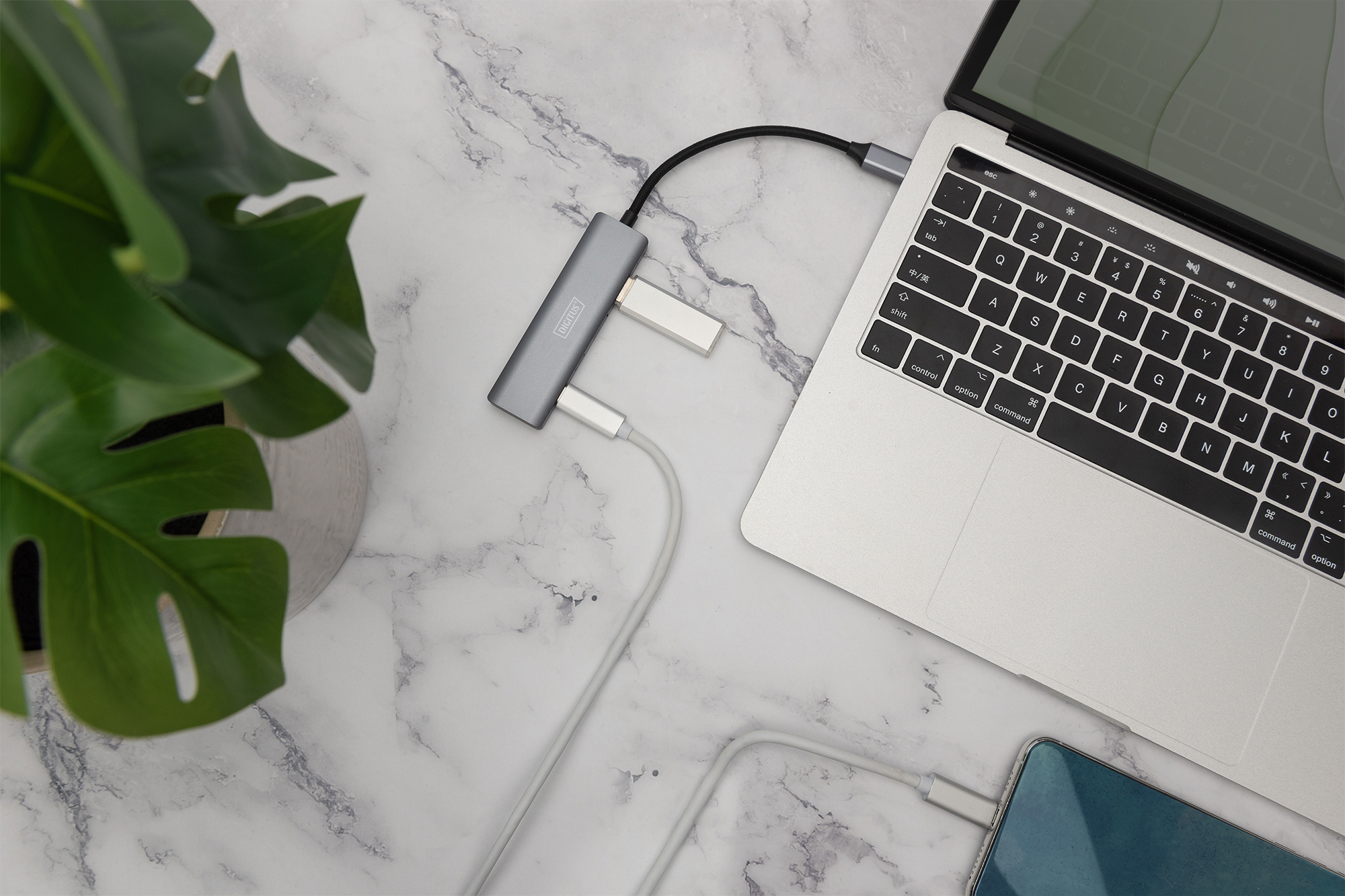 Un laptop con hub USB-C collegato a uno smartphone.
