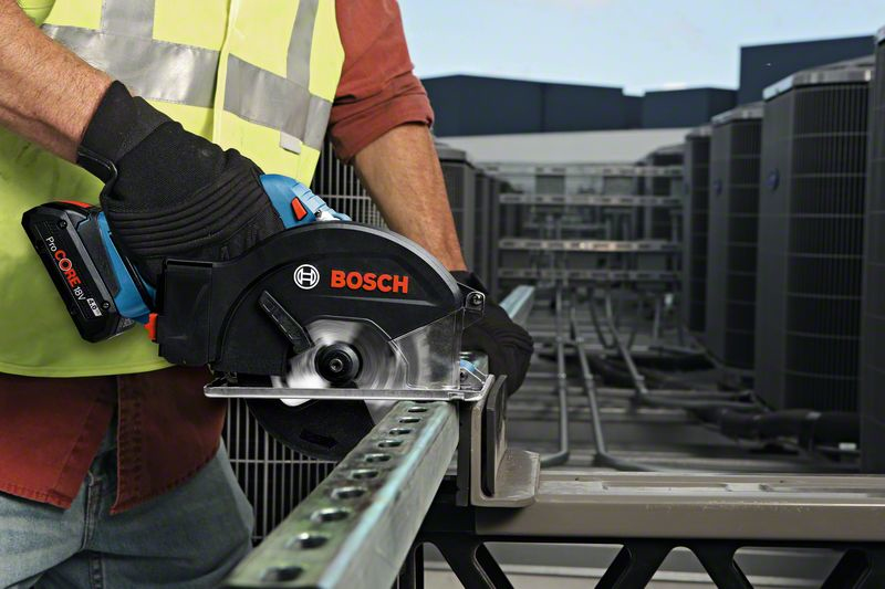 Operaio taglia profilato metallico con sega circolare Bosch sul tetto.