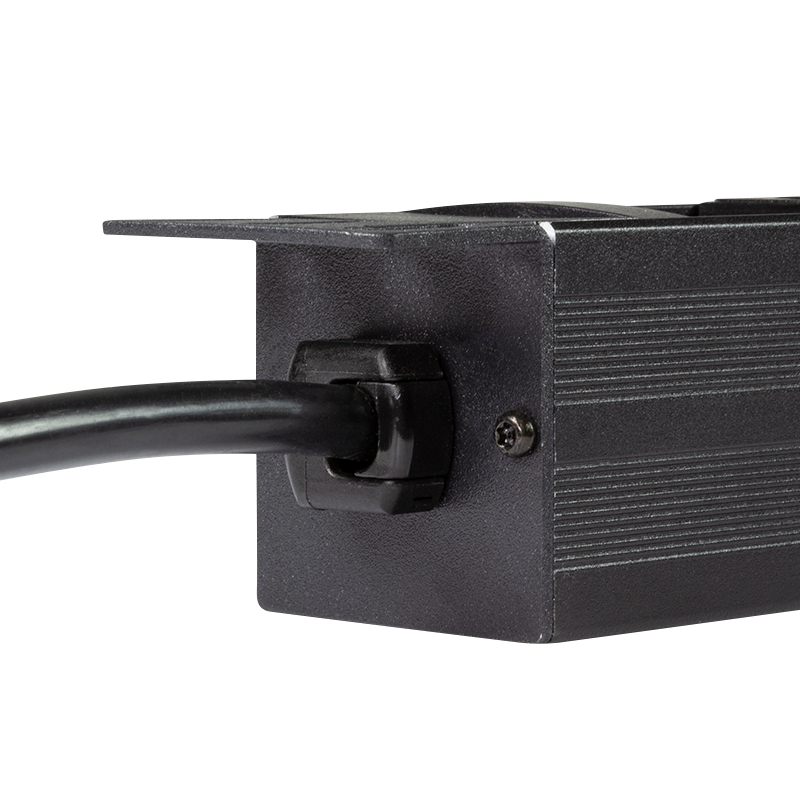 Ein schwarzes Kabel wird in eine schwarze Buchse an einem schwarzen Metallgehäuse geführt.