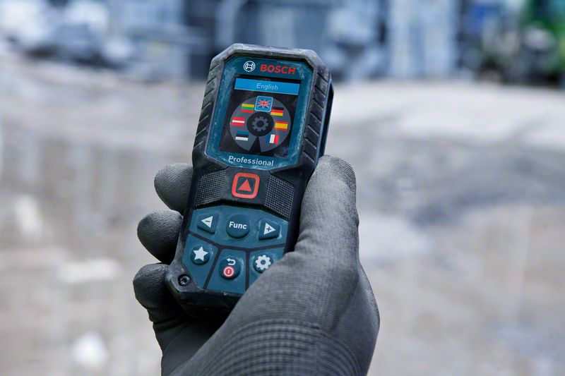 Hand hält Bosch Entfernungsmesser mit Sprachauswahlbildschirm.