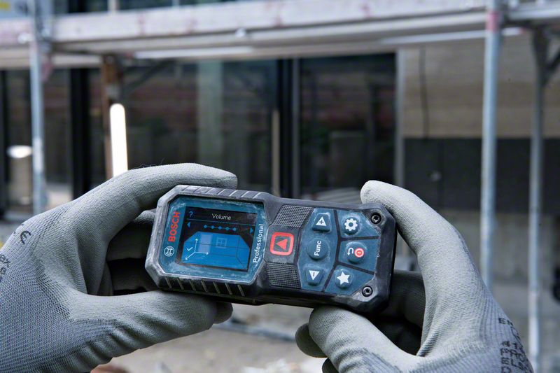 Hände in grauen Handschuhen halten ein Bosch Laser-Entfernungsmesser mit blauem Bildschirm.