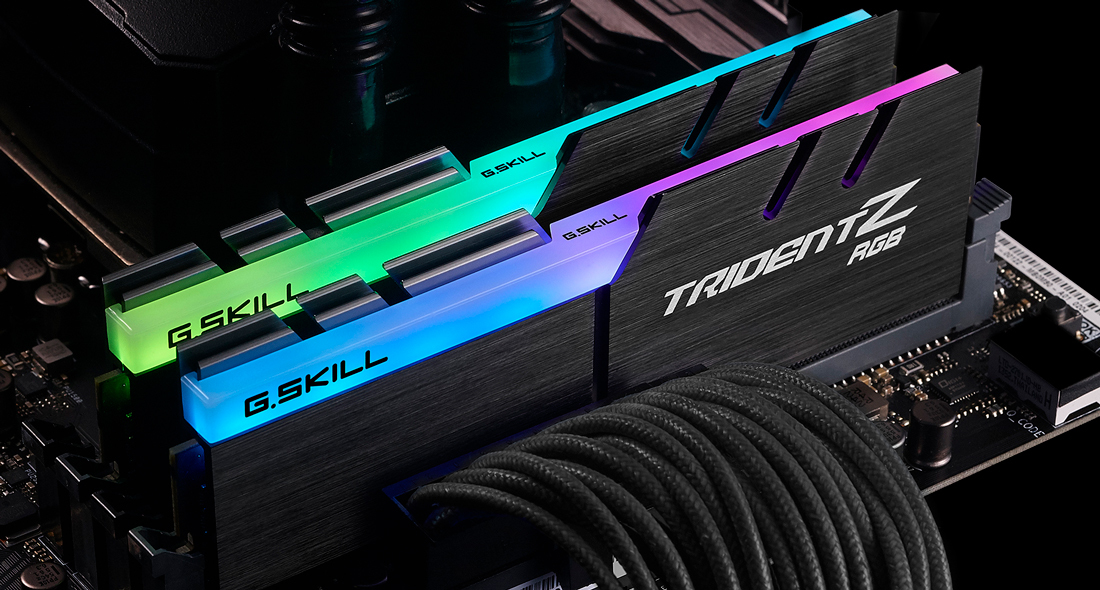 Zwei G.Skill Trident Z RGB RAM-Module auf einem Motherboard mit grüner und blauer Beleuchtung.