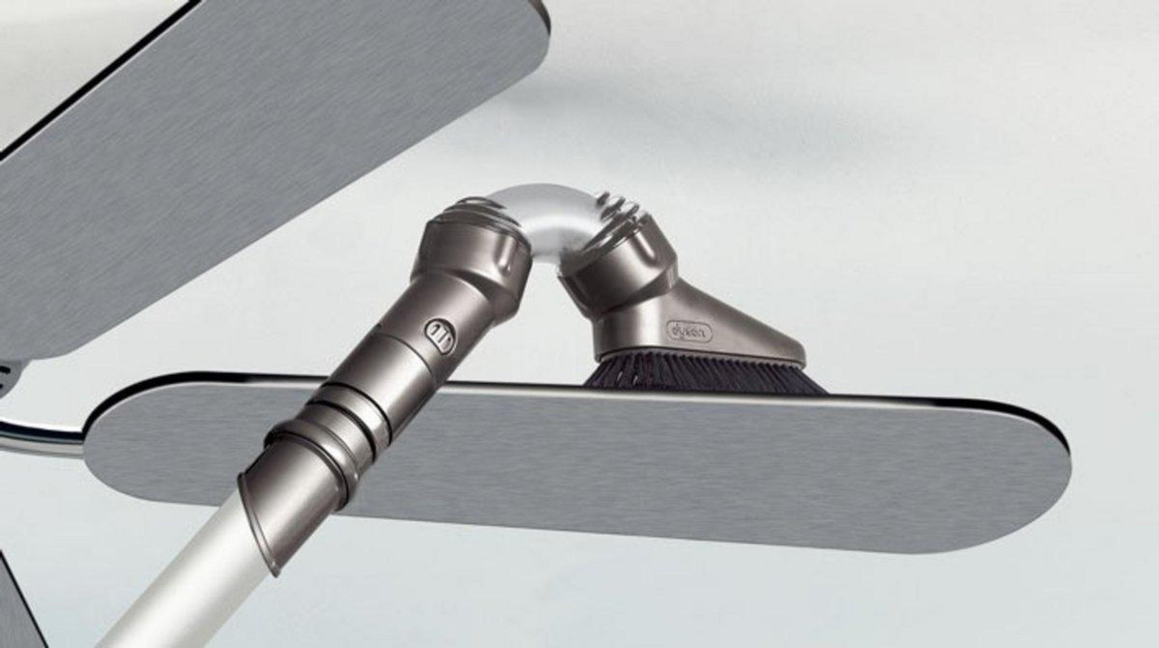 Un accessorio per aspirapolvere Dyson con spazzola e snodo su una parte metallica.