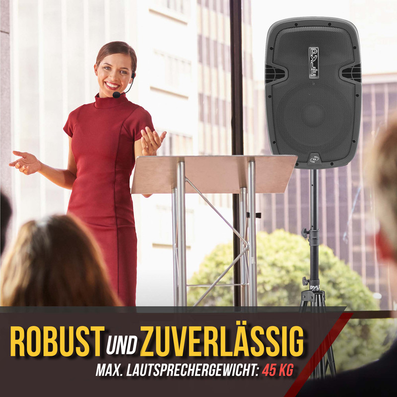 Eine Frau in Rot spricht an einem Podium, daneben ein Lautsprecher.