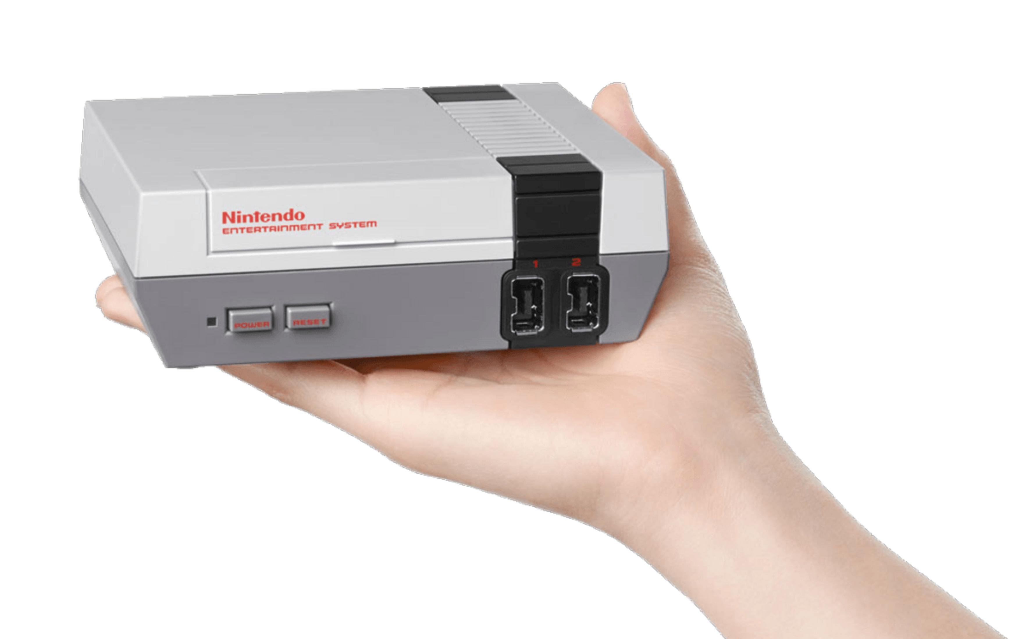 Eine Hand hält eine Miniatur-Konsole des Nintendo Entertainment Systems in Grau und Weiß.