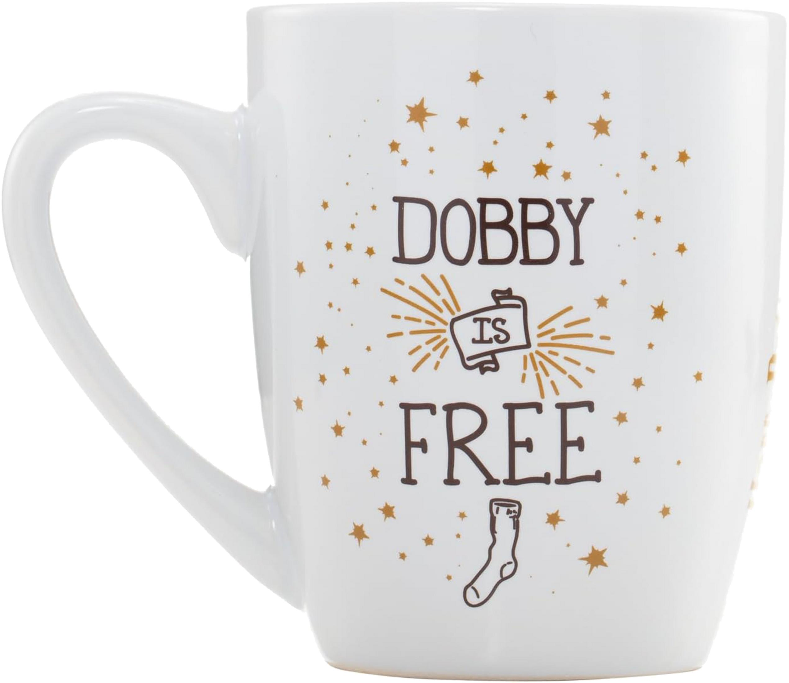 Una taza blanca con texto marrón "DOBBY IS FREE" y pequeñas estrellas doradas.