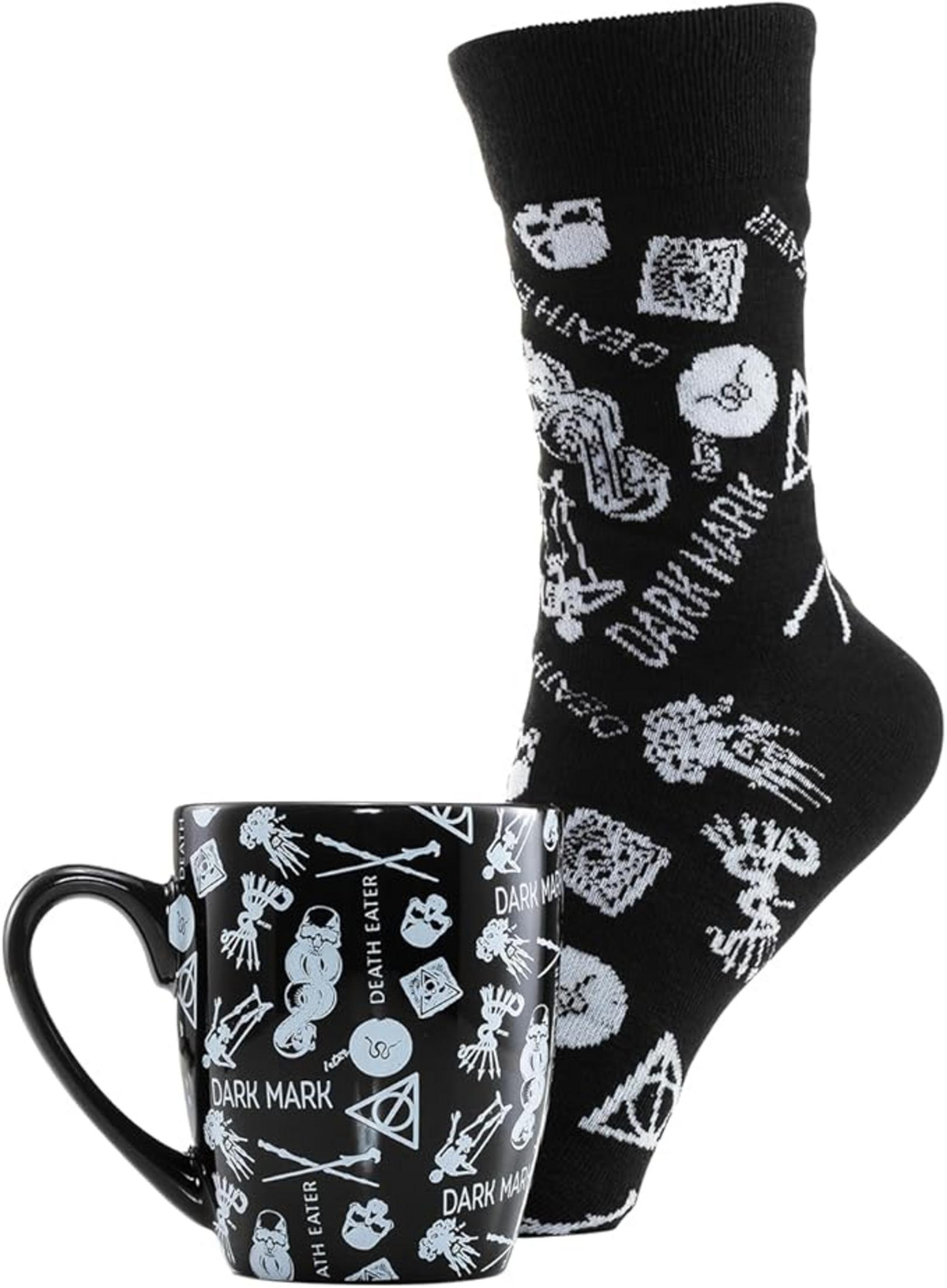 Taza y calcetín negros con imágenes blancas de calaveras, serpientes y símbolos.