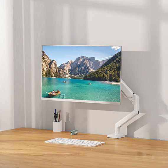Biały monitor na ramieniu wyświetla spokojne jezioro z łodziami i górami.