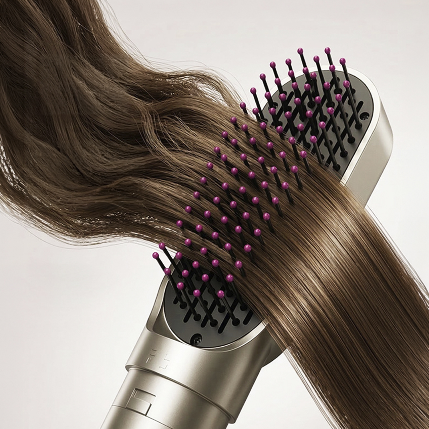 Un pettine con punte rosa passa tra capelli castani lucidi.