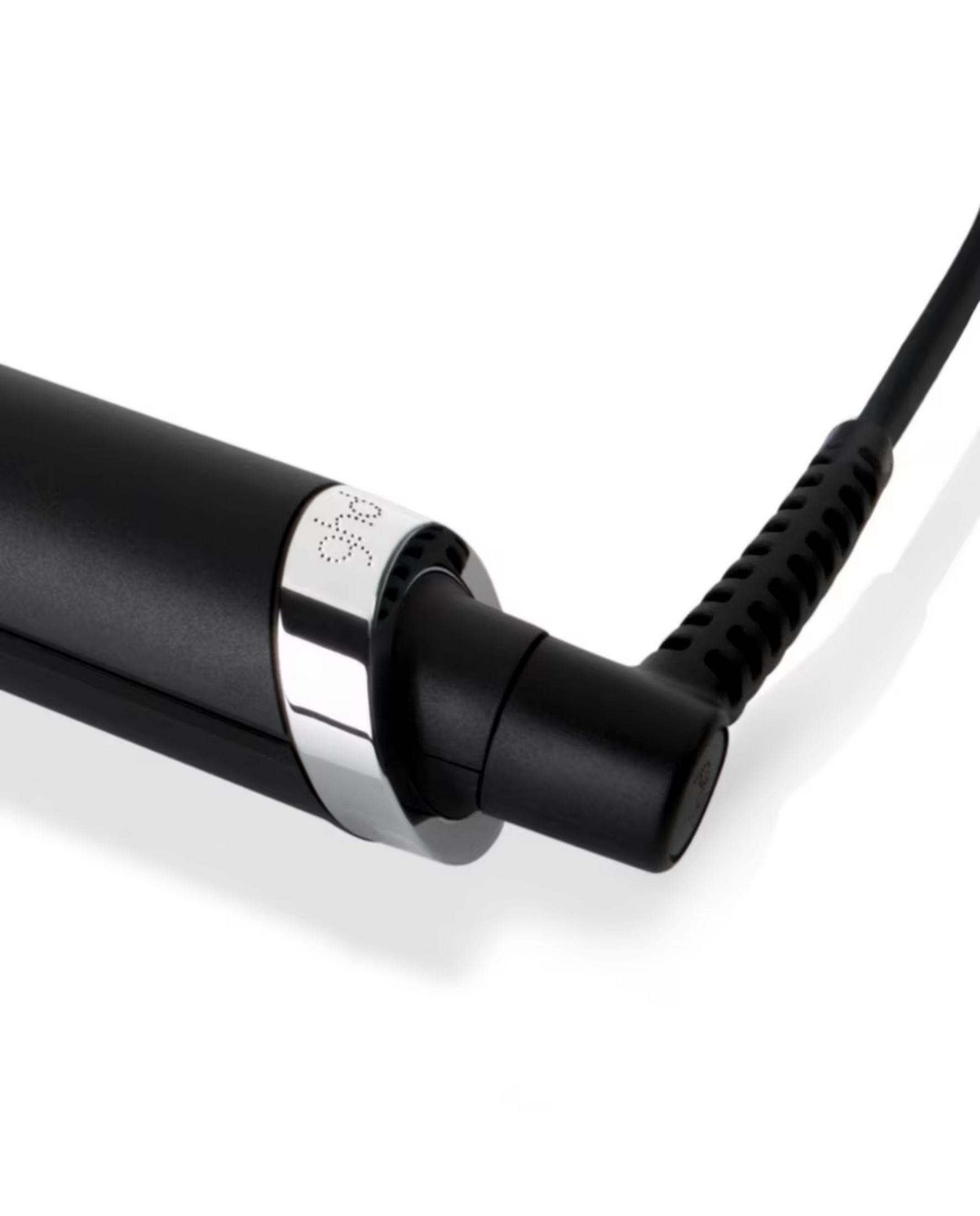 Primer plano de una plancha para el pelo negra con anillo plateado y cable.