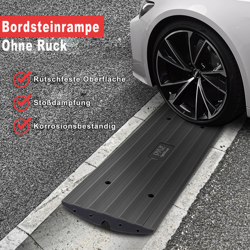 Eine Bordsteinrampe aus schwarzem Gummi liegt auf der Straße, ein Autoreifen darauf.