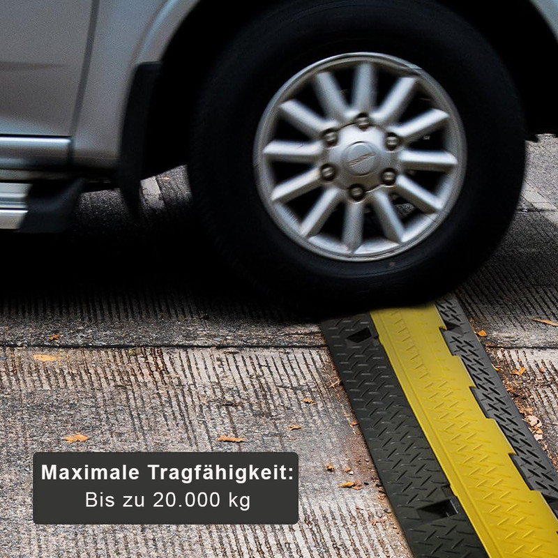 Ein Auto fährt über eine gelbe und schwarze Rampe auf einer Straße.