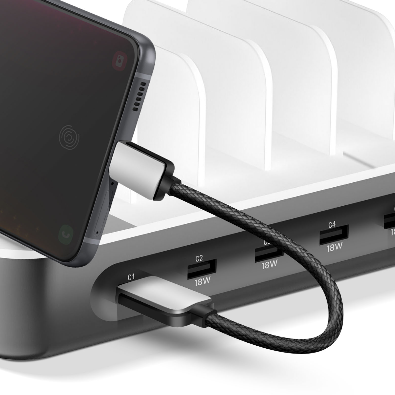 Ein Smartphone wird an einer Mehrfach-USB-Ladestation mit mehreren Steckplätzen aufgeladen.