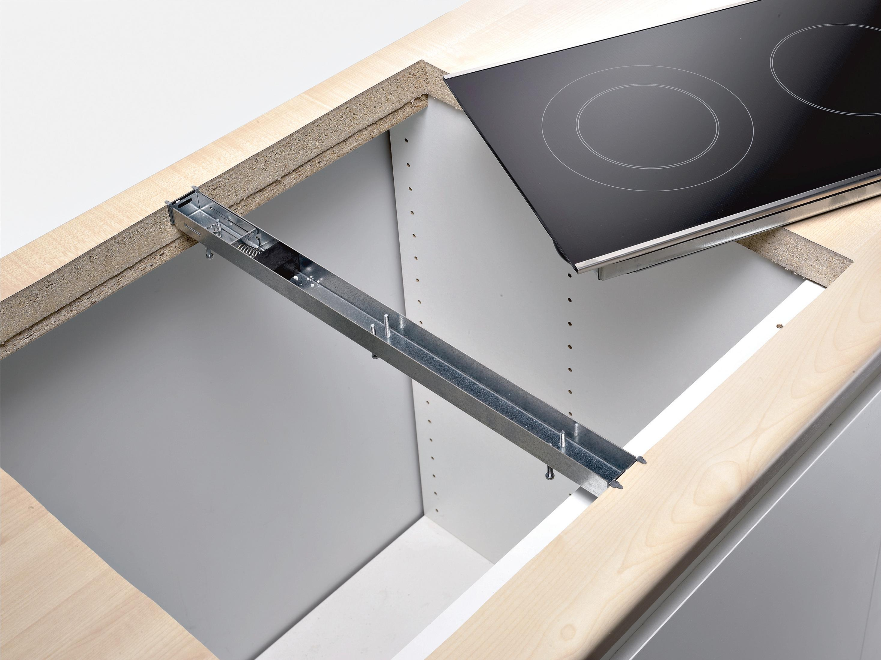 Installazione di un piano cottura a induzione con guide metalliche e finiture in legno.