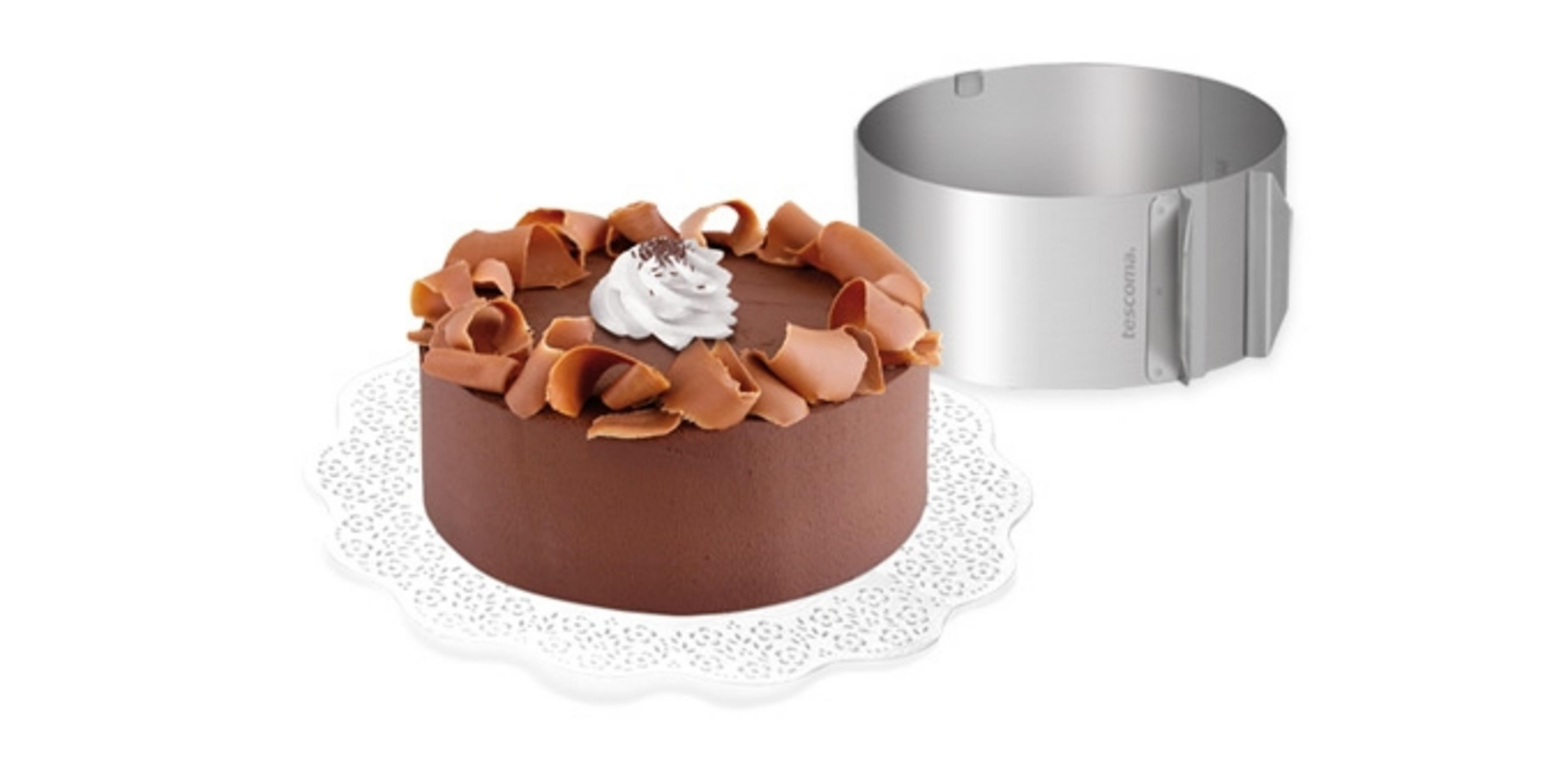 Schokoladenkuchen mit Sahnetupfer und Schokostückchen, daneben ein Metallring.