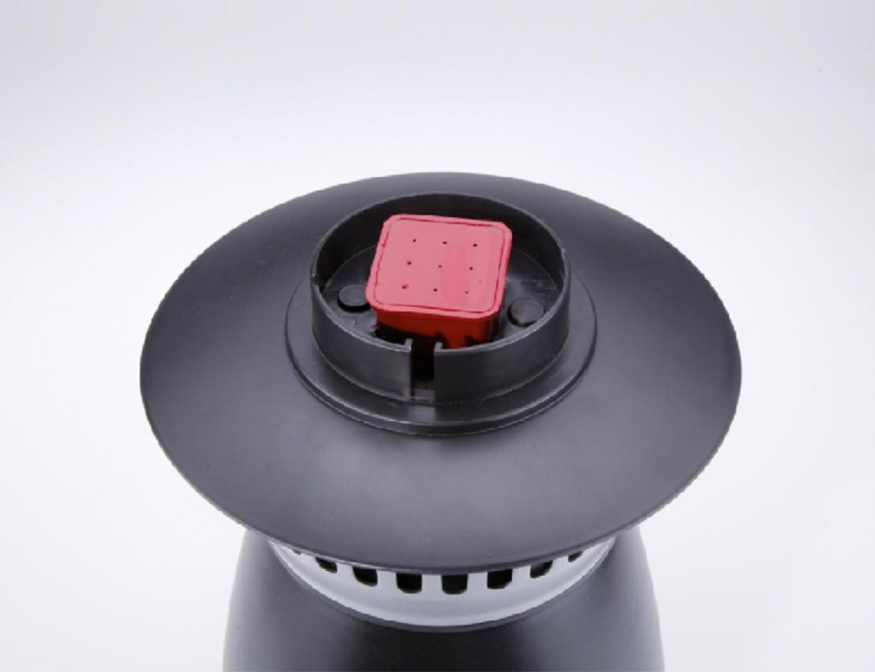 Un dispositivo negro con una parte superior cuadrada roja con orificios de ventilación.