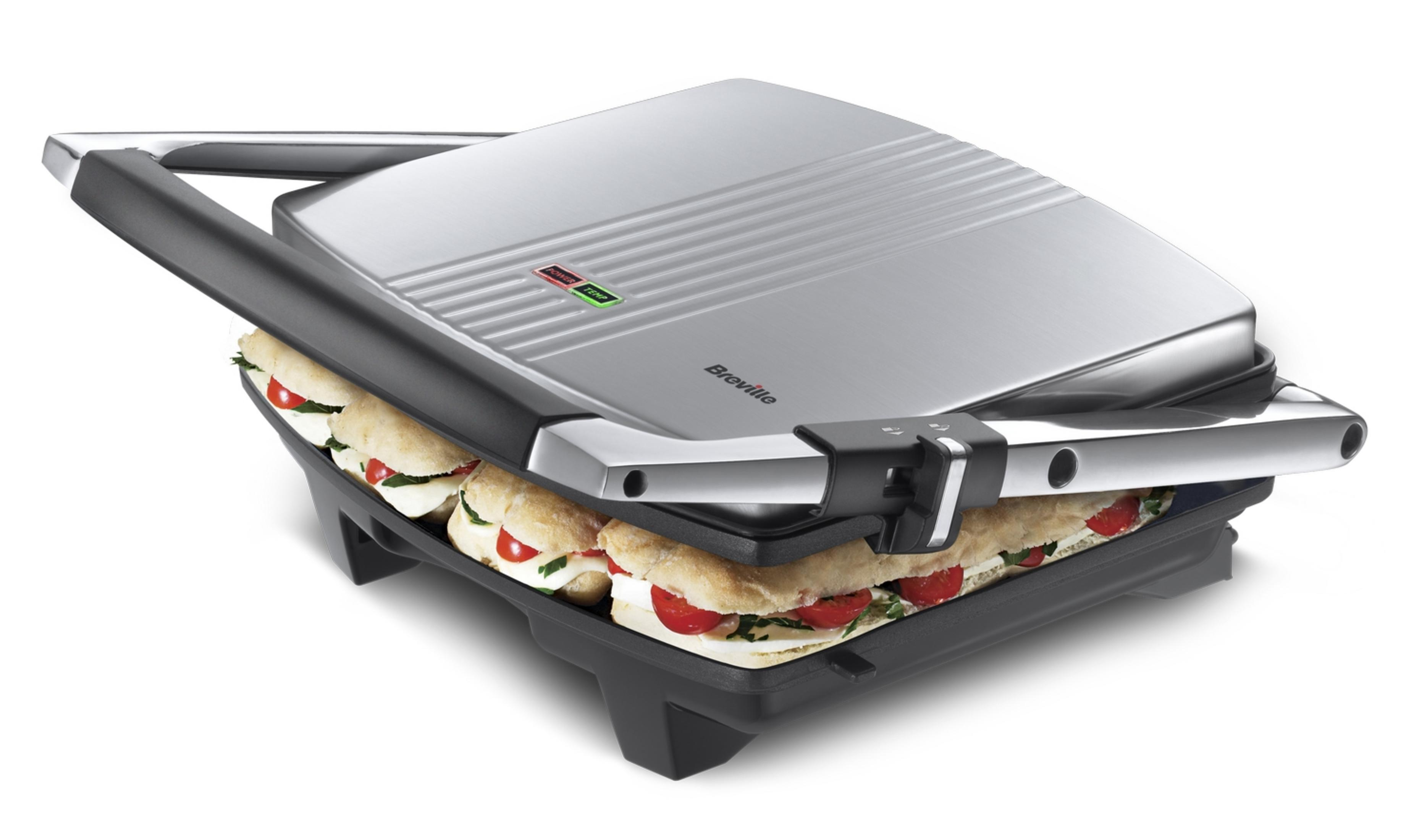 Ein silberner Kontaktgrill mit drei Sandwiches, die darauf zubereitet werden.