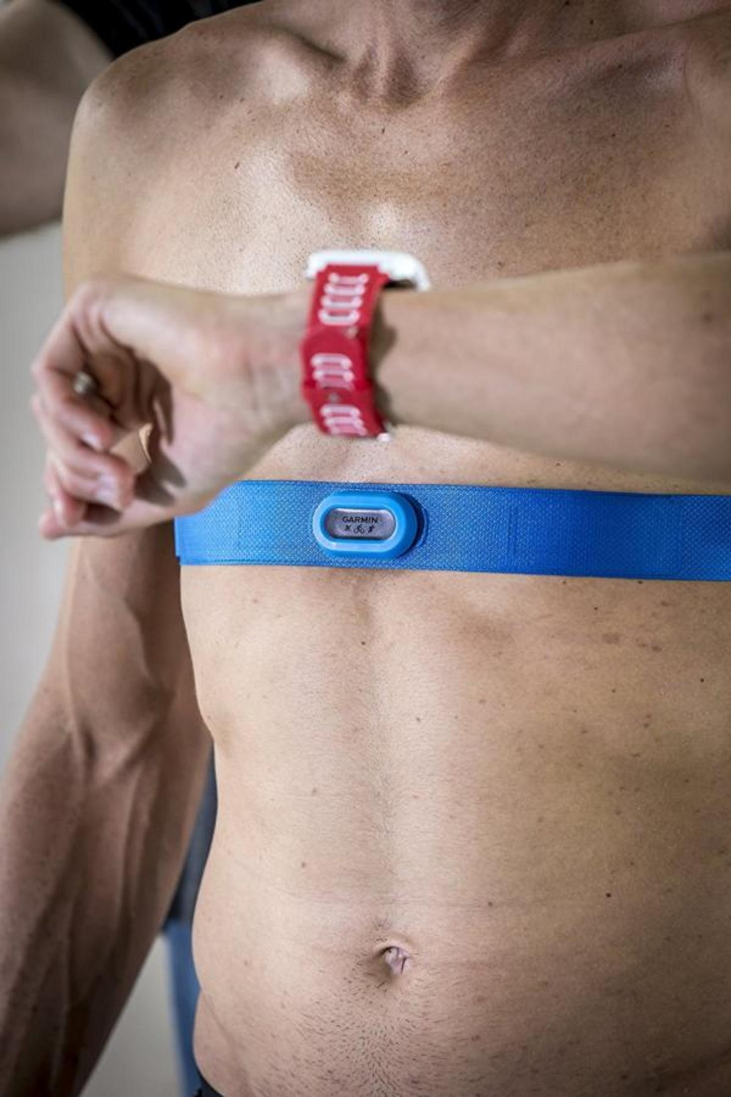 Ein Mann mit Herzfrequenz-Brustgurt und Armbanduhr, Nahaufnahme.