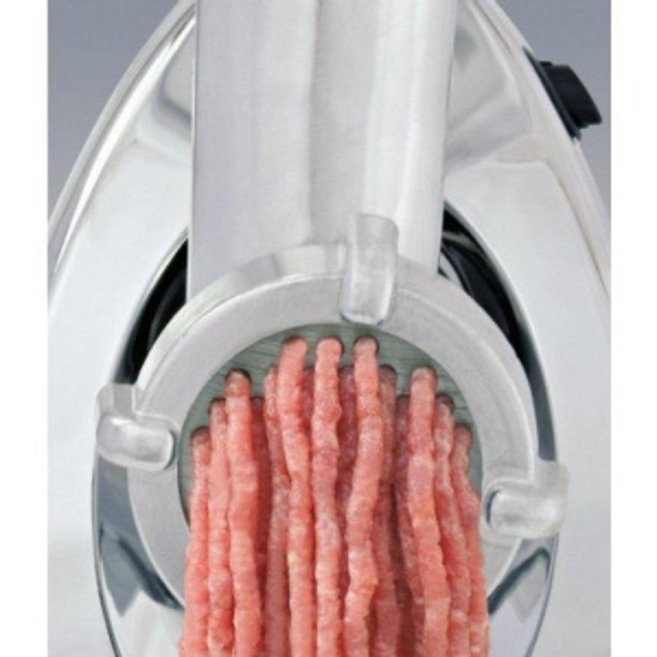 Una piastra per tritacarne con carne macinata fresca che esce.