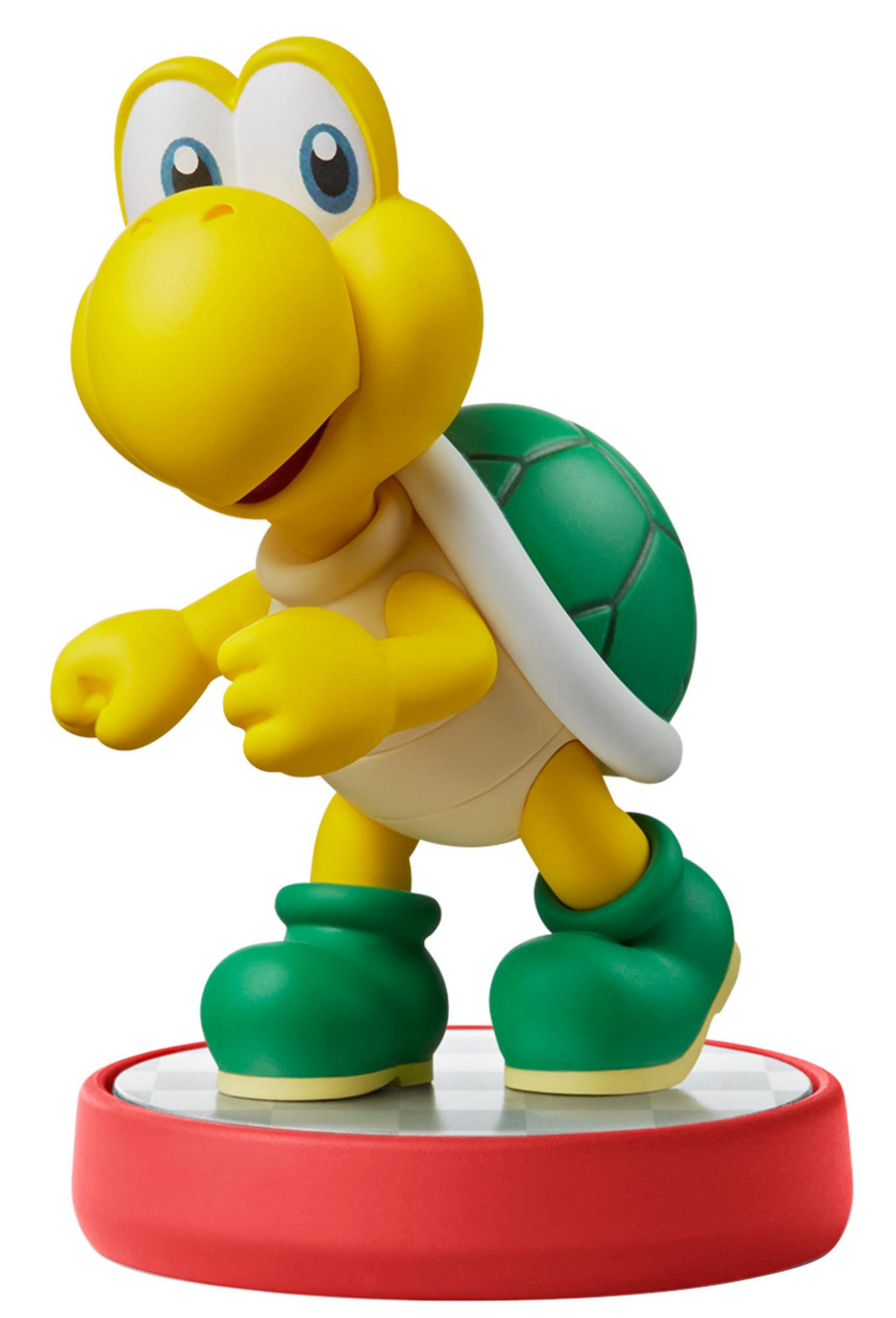 Une figurine de tortue jaune avec une carapace et des bottes vertes se tient sur une base rouge.
