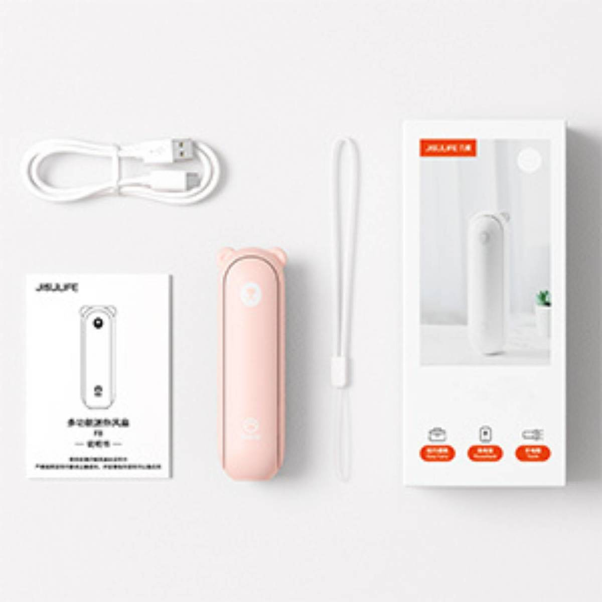 Ein rosafarbener Mini-Ventilator mit Bärenohren, Ladekabel, Handschlaufe und Verpackung.
