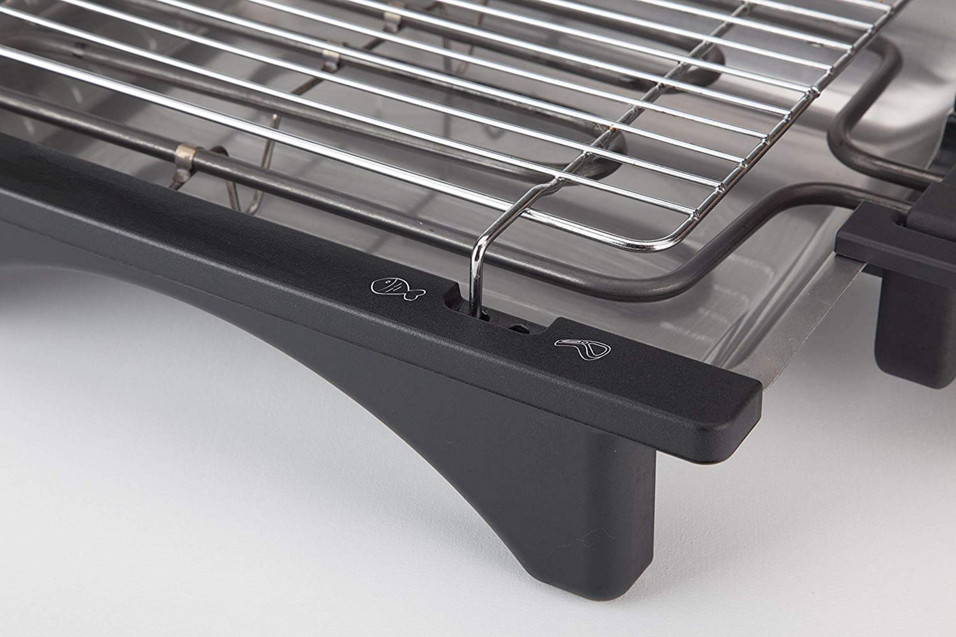 Primo piano di una griglia elettrica con griglia cromata e manico nero.