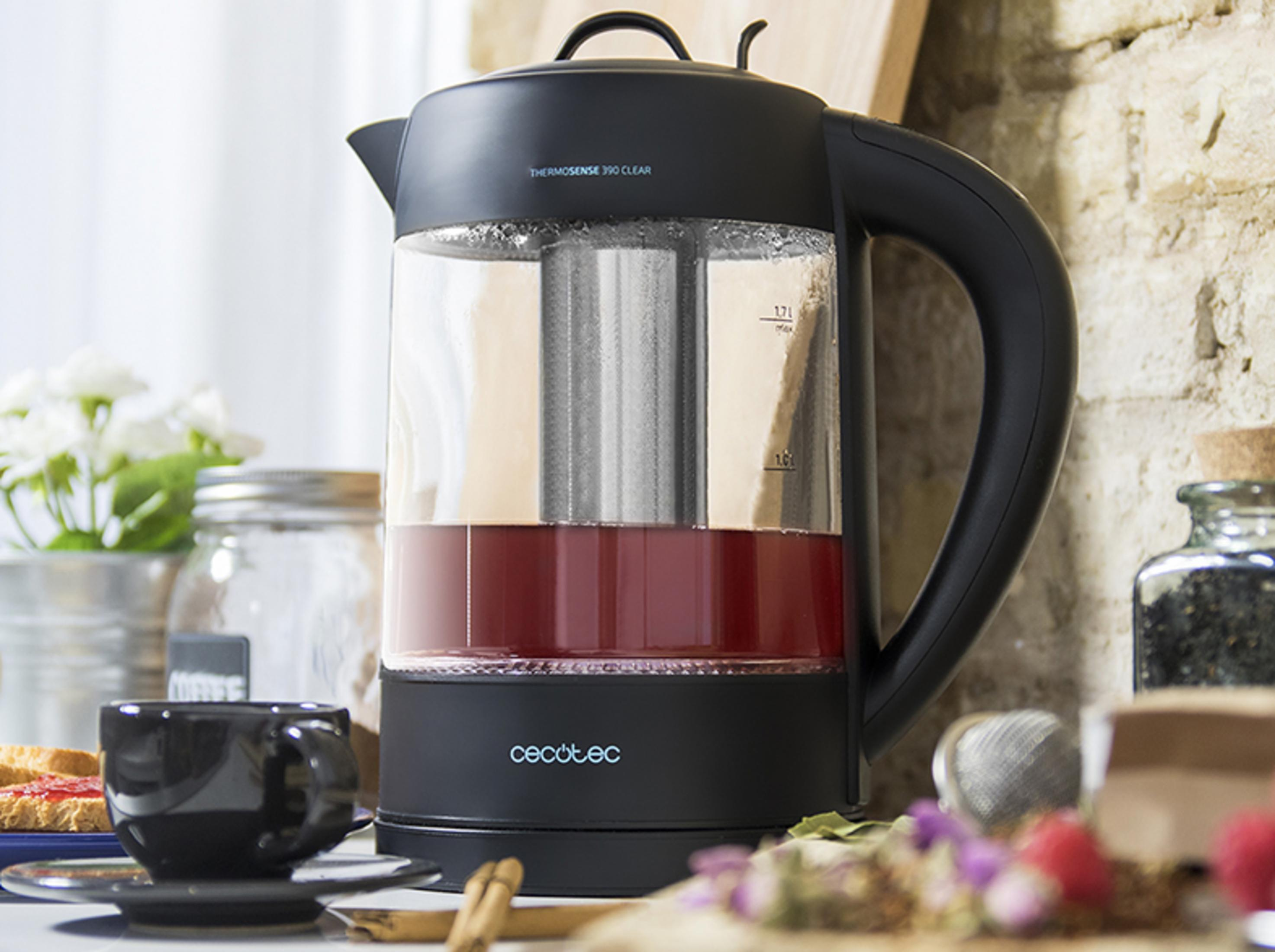 Ein schwarzer Wasserkocher mit rotem Tee und einem Kräutertee-Sieb.