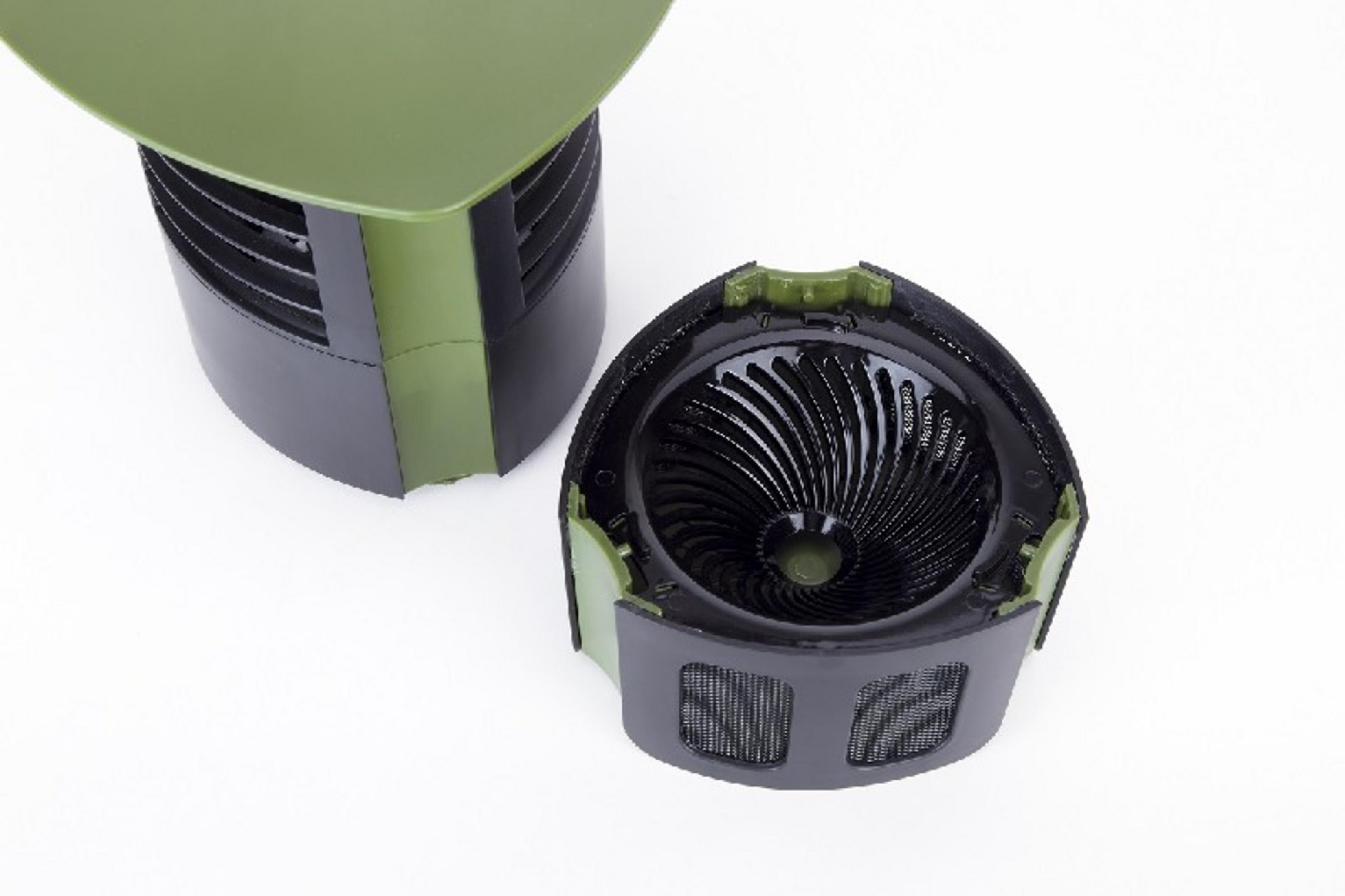 Una tapa verde descansa sobre una carcasa de ventilador negra con rejillas de ventilación.