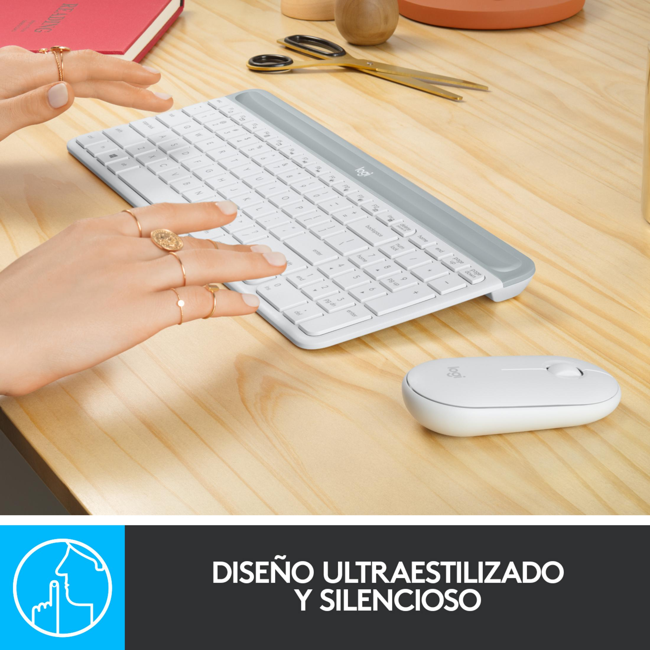 Una mano digita su una tastiera bianca, con un mouse bianco accanto.