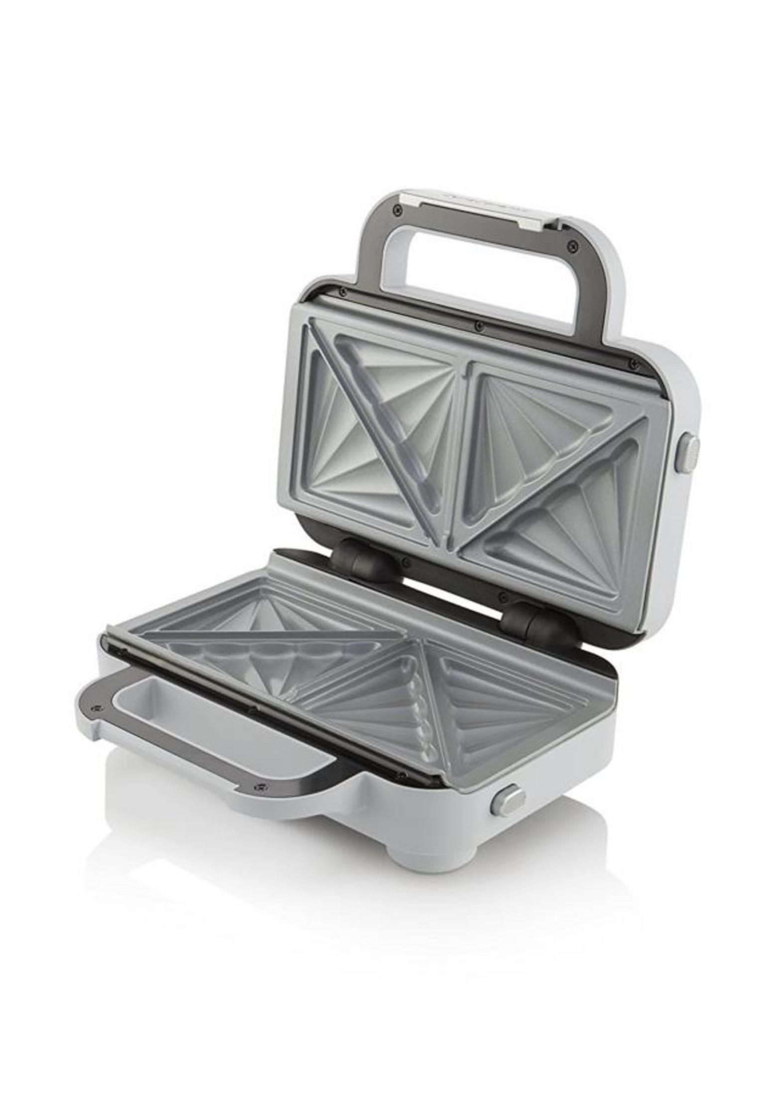 Ein offener, weißer Sandwichmaker mit silbernen Heizplatten für Dreiecke.
