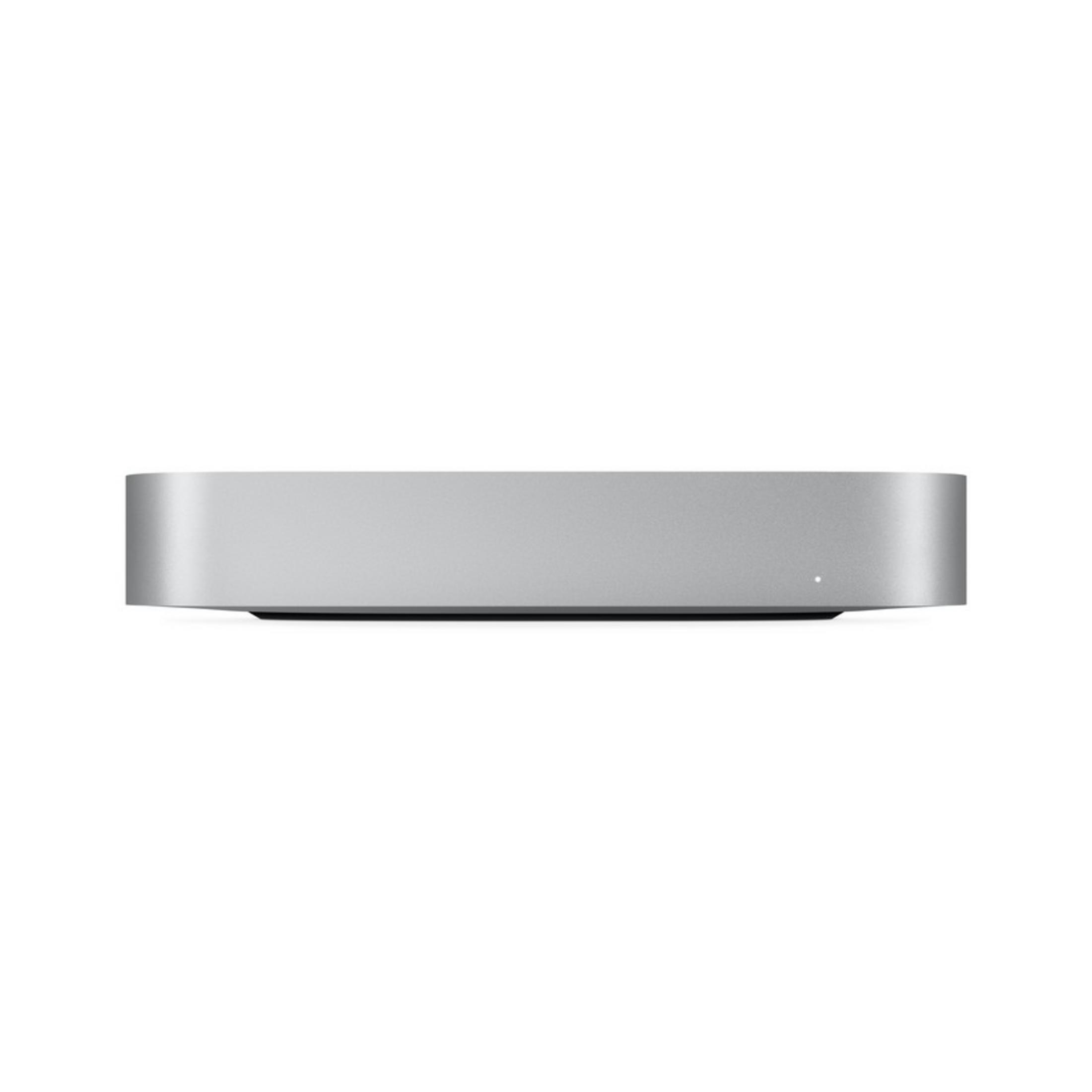 Un Mac Mini argentato su sfondo bianco. Una piccola luce bianca è accesa.