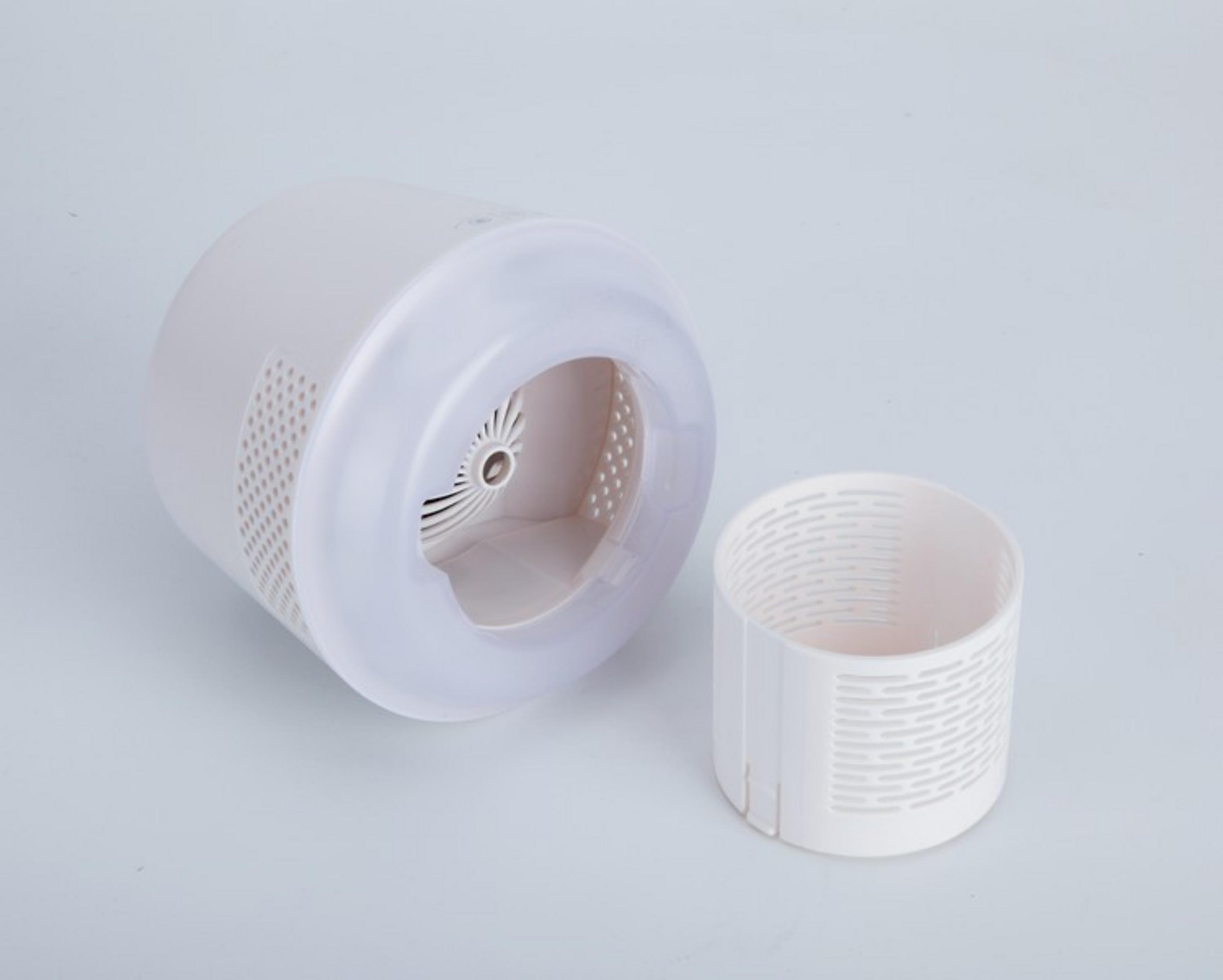 Un ventilador blanco con una rejilla extraíble sobre un fondo gris claro.