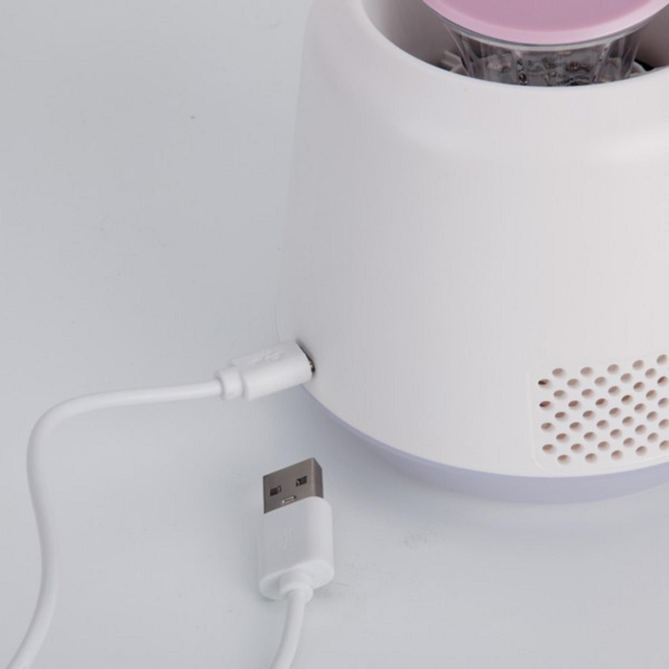 Un cable USB blanco se conecta a un dispositivo blanco con patrón de rejilla.