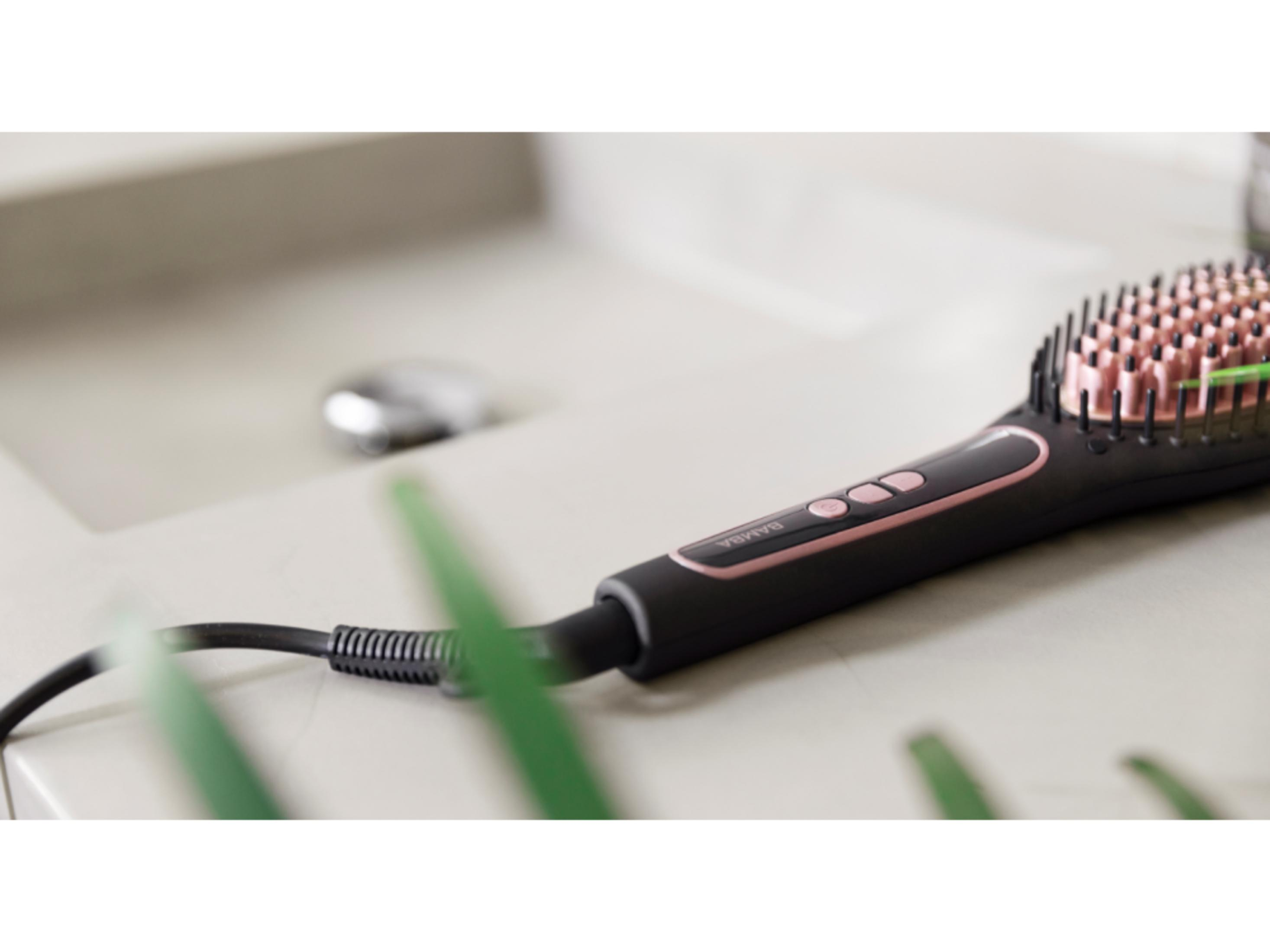 Una spazzola lisciante nera con setole rosa, appoggiata su un lavandino.