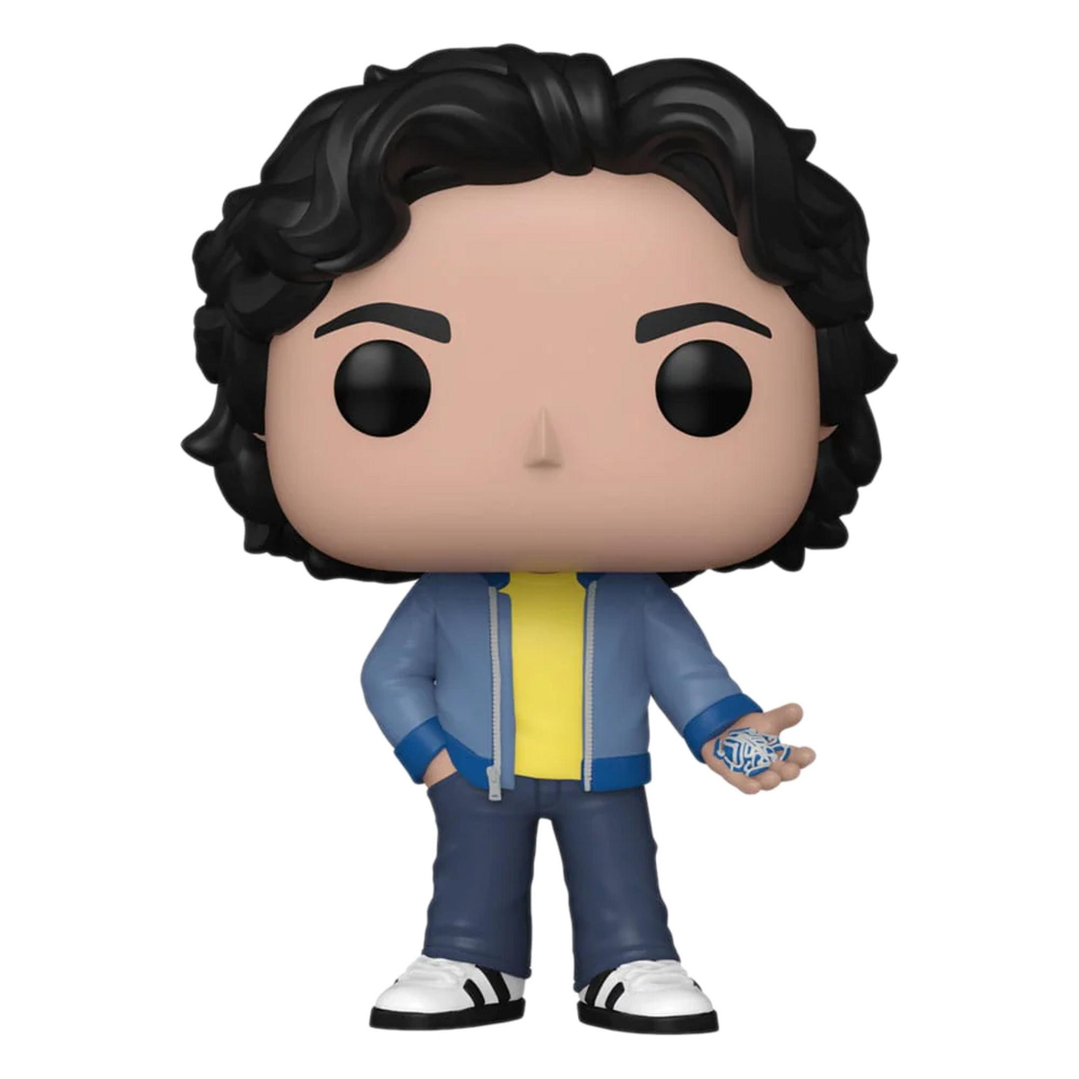 Una figura con pelo negro, camisa amarilla, chaqueta azul y jeans. Sostiene algo azul.